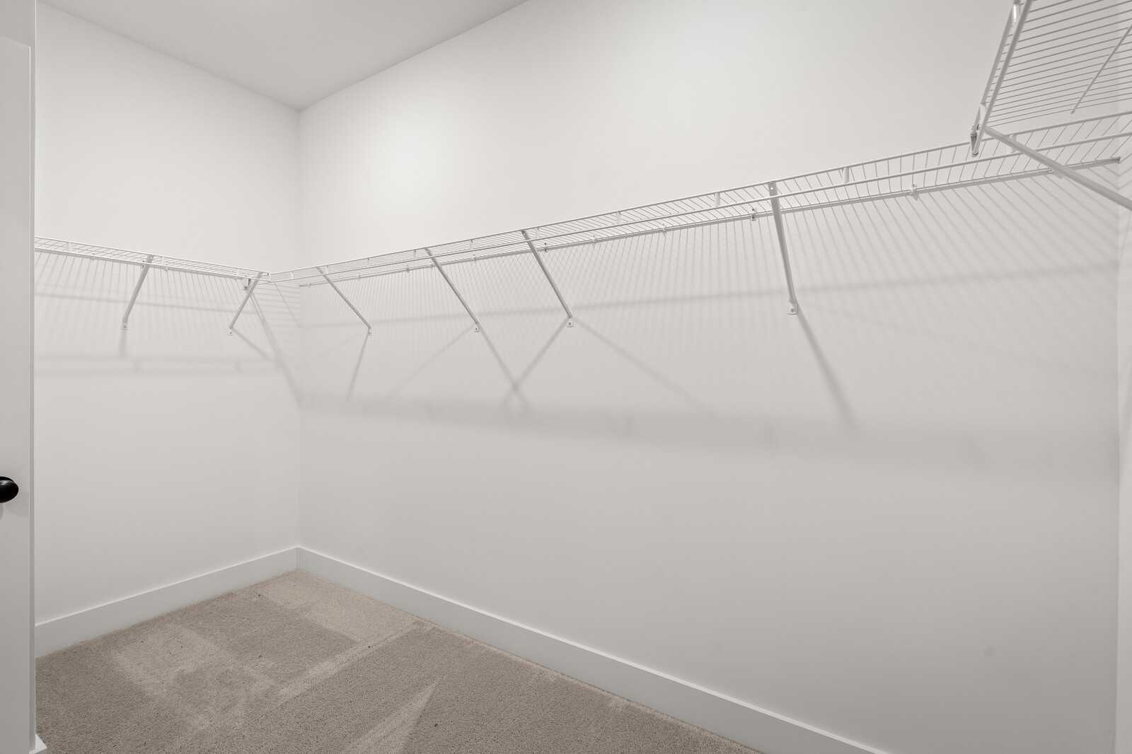 Spacious walk-in closet with wire shelving and carpet flooring in Davidson Homes The Ridgeport, Carellton, Gallatin, Tennessee