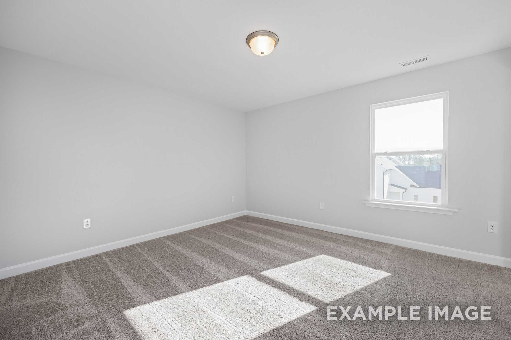 Spacious upstairs bedroom in The Cypress D II with light gray walls, plush carpet flooring, large window, and ceiling light