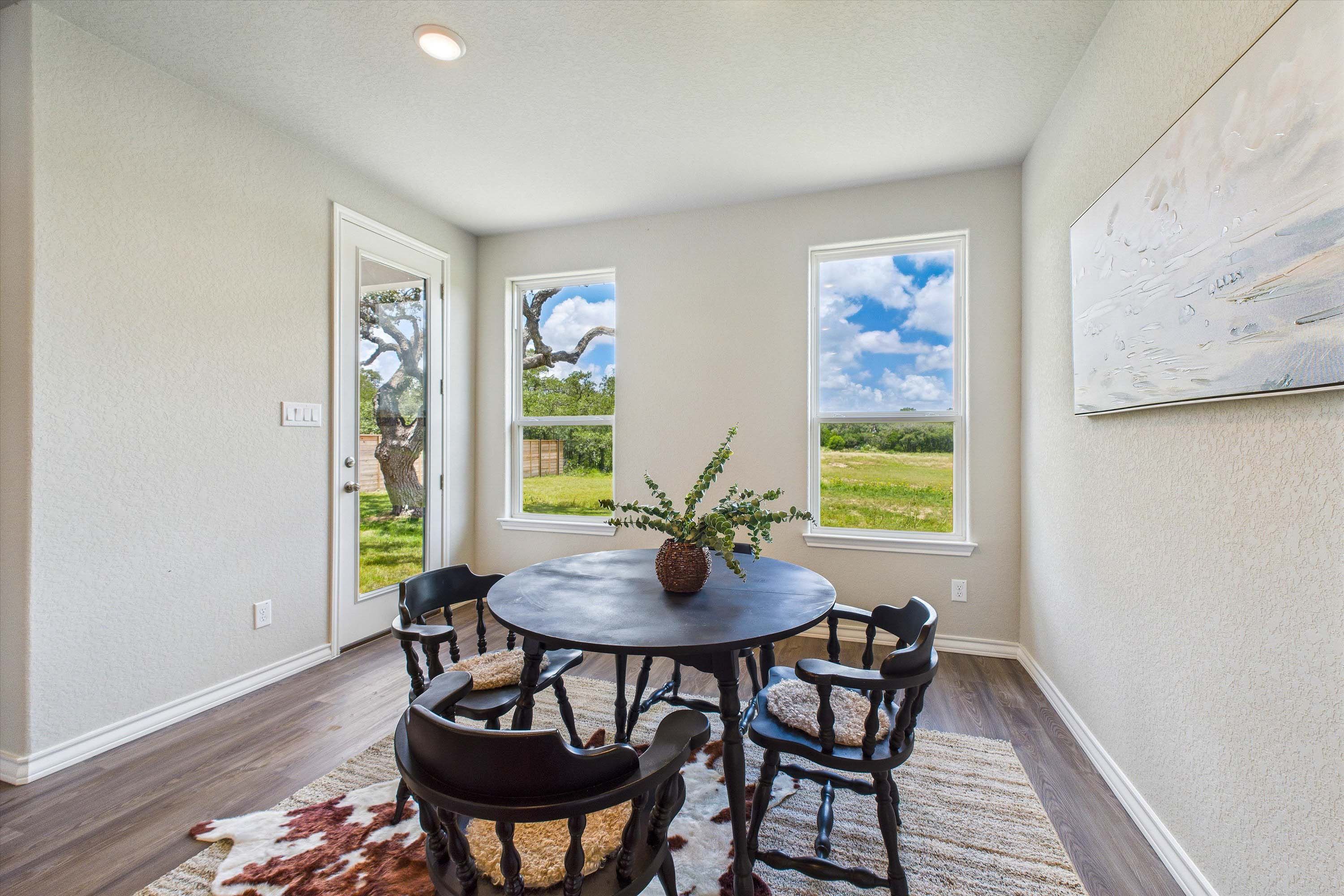 Bright breakfast nook featuring a round table and scenic backyard views in The Foster home design by Davidson Homes.