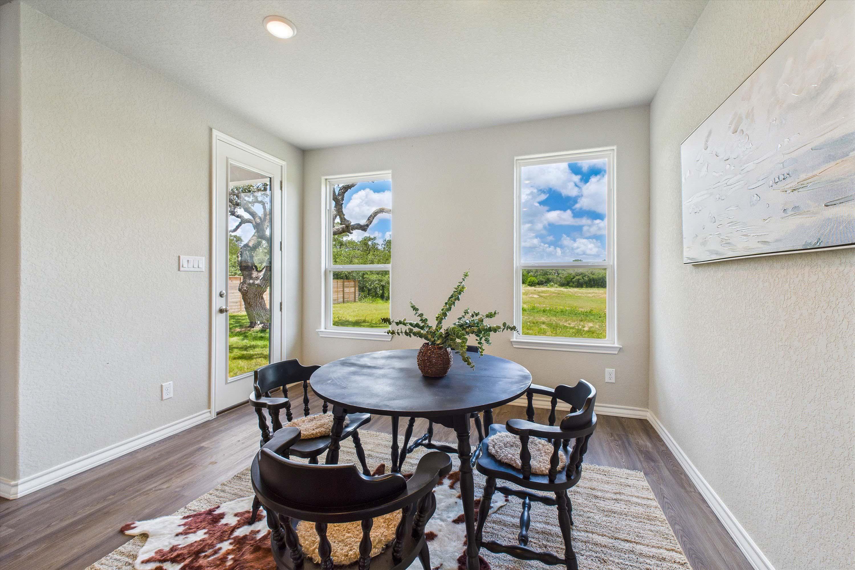 Bright breakfast nook featuring a round table and scenic backyard views in The Foster home design by Davidson Homes.