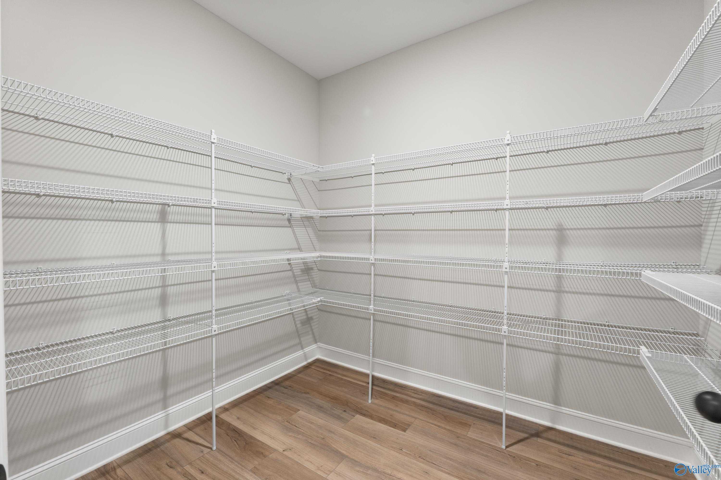 Spacious walk-in pantry with white wire shelving lining walls in The Finleigh floor plan, Davidson Homes, Toney, Alabama