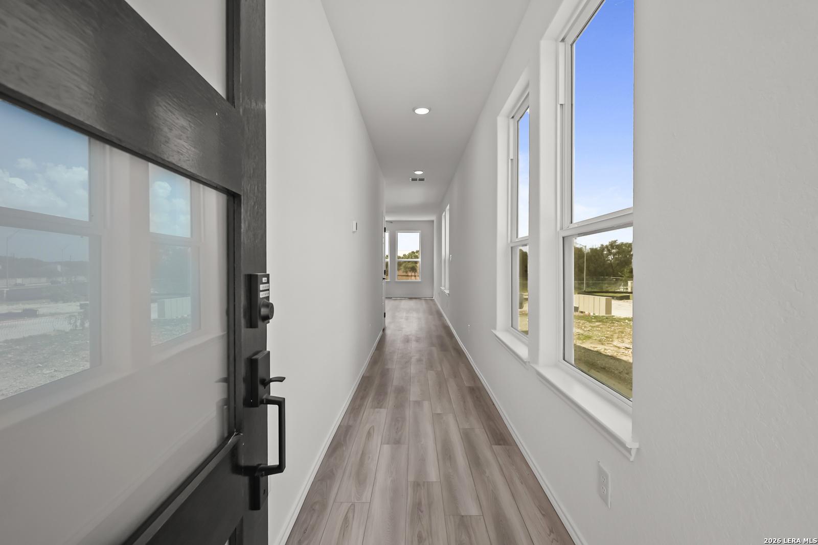 Bright entryway with wood-look flooring in The Florence B floor plan at Meadows at Oak Creek, San Antonio, Texas.