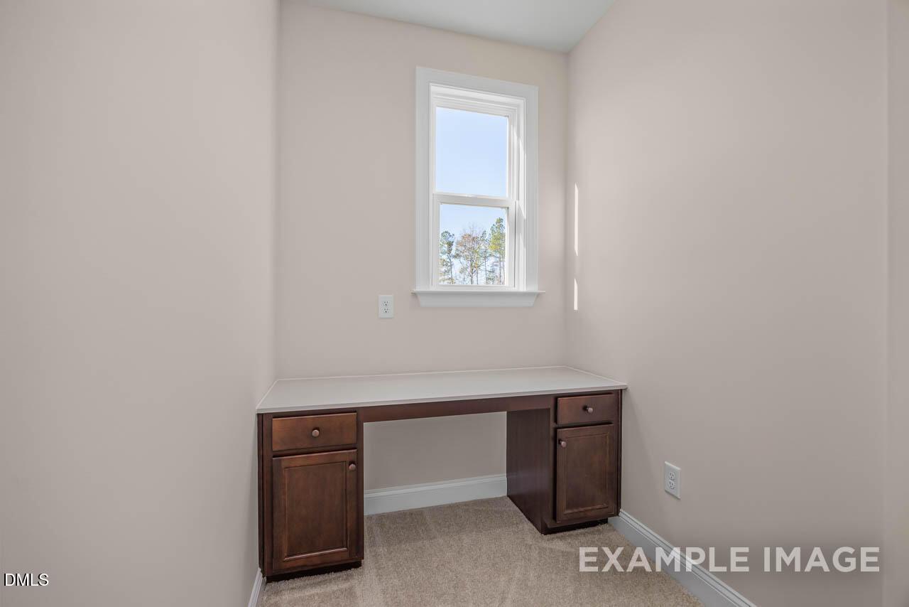 Cozy home office with wooden built-in desk and sunlit window in Davidson Homes The Crawford D, Angier, NC