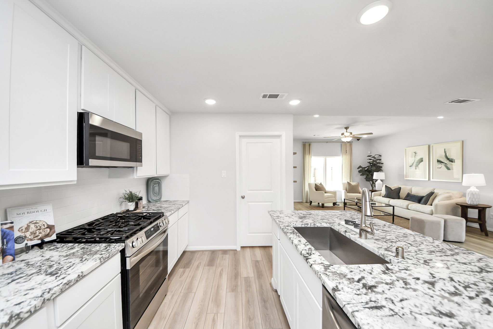 Modern kitchen with granite island and white cabinets at Sunterra in Katy, Texas by Davidson Homes.