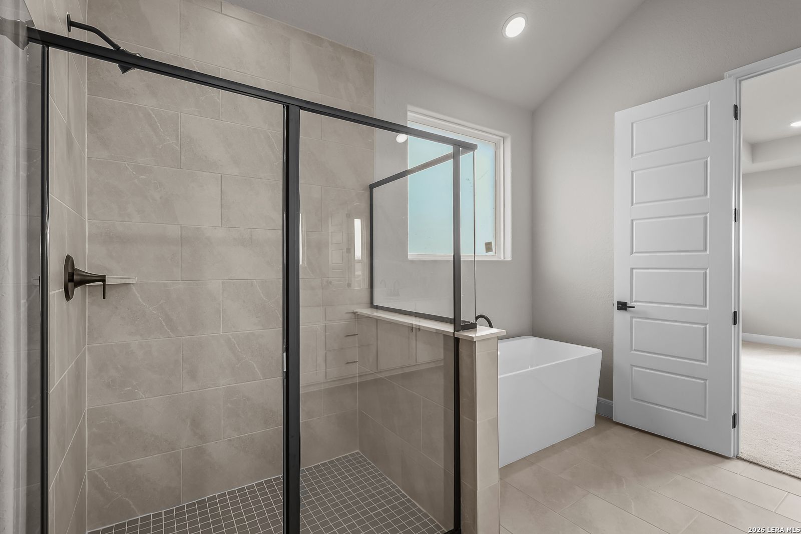 Modern master bathroom with walk-in glass shower and freestanding tub in Davidson Homes The Foster E, Castroville, TX