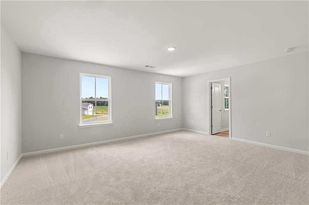 Spacious, neutral-toned bedroom in The Russell A floor plan by Davidson Homes at Cedar Farms in Winder, Georgia.