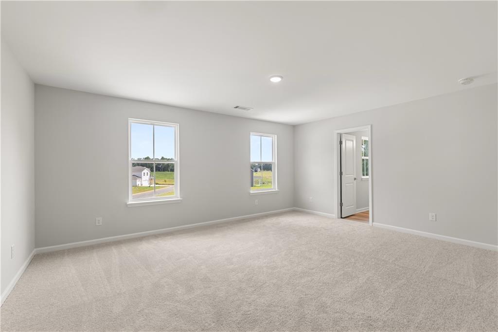 Spacious, neutral-toned bedroom in The Russell A floor plan by Davidson Homes at Cedar Farms in Winder, Georgia.
