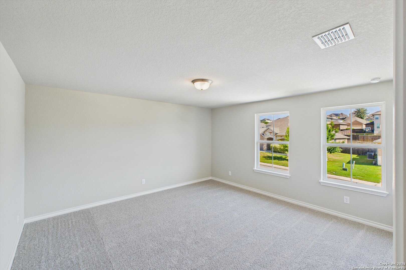 Bright secondary bedroom with large windows overlooking green lawn in Davidson Homes The Jennings H, Ladera, San Antonio