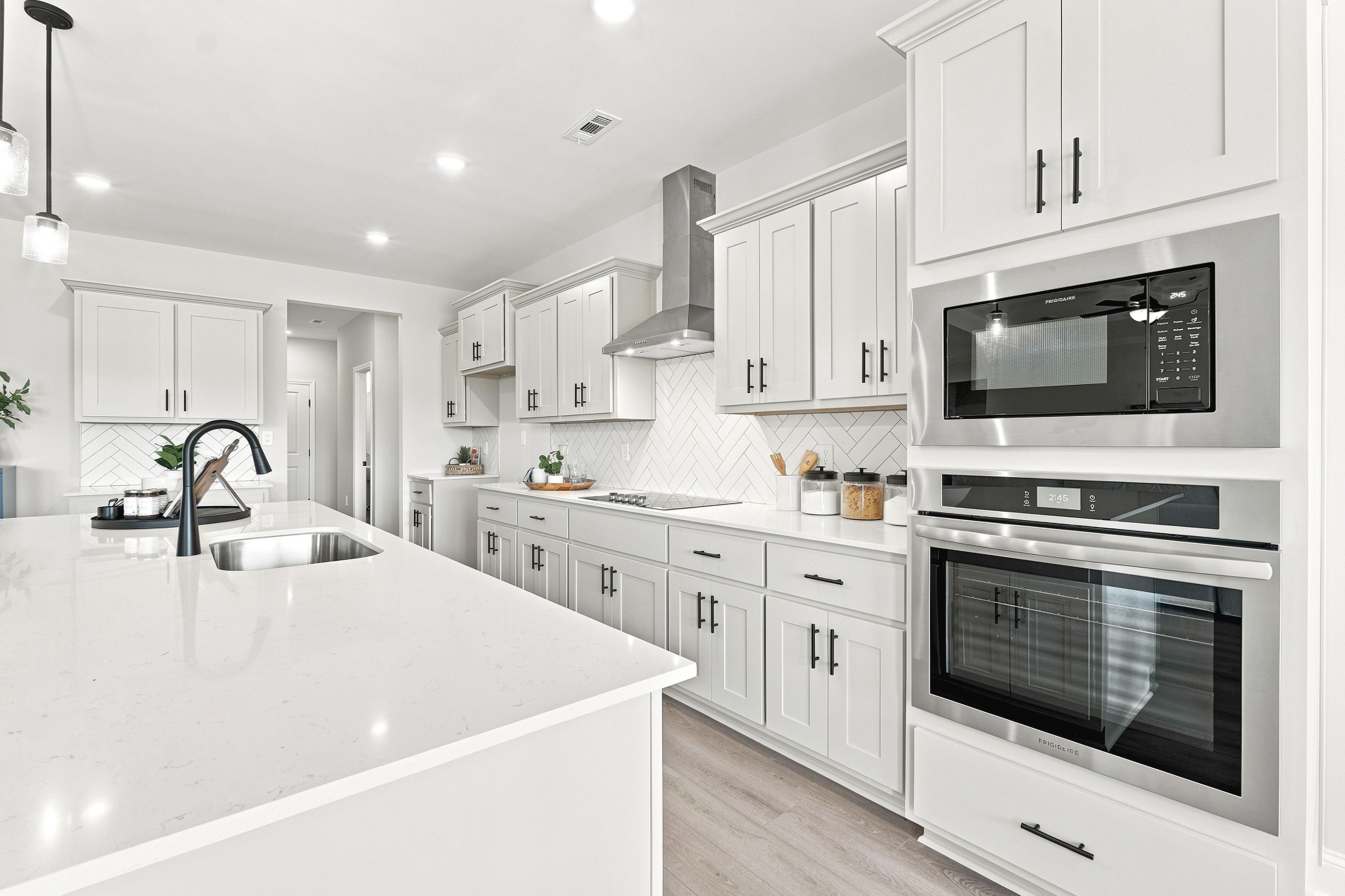 Modern kitchen at Riverton Preserve in Huntsville, AL featuring white cabinetry, quartz countertops, and stainless appliances.