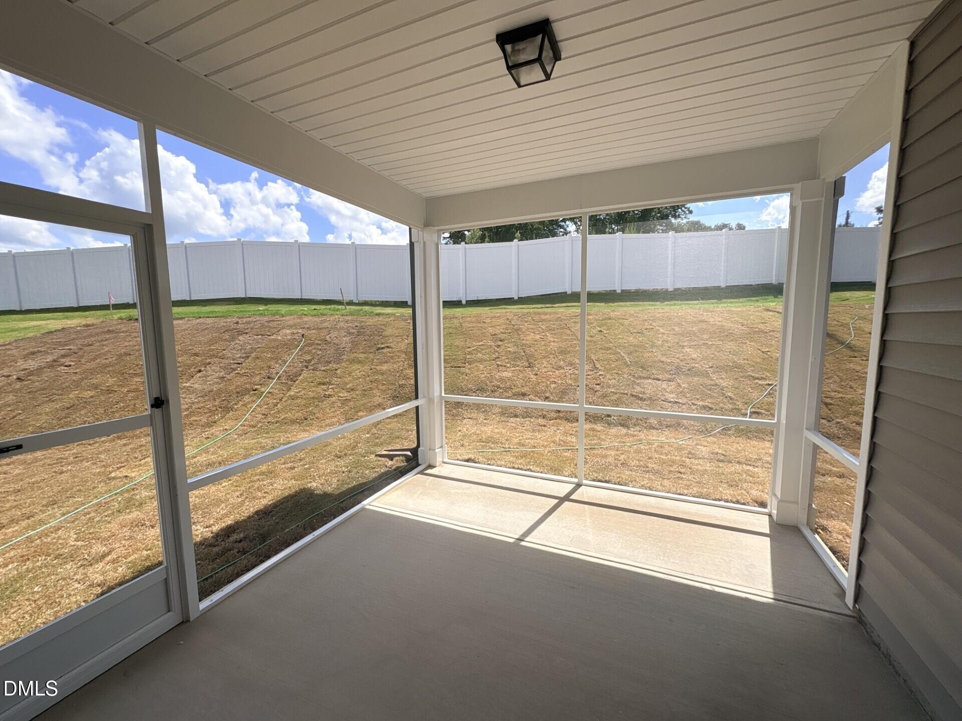 Screened-in porch overlooking fenced backyard at The Ash C floor plan in Woodland Crossing, Zebulon, North Carolina.
