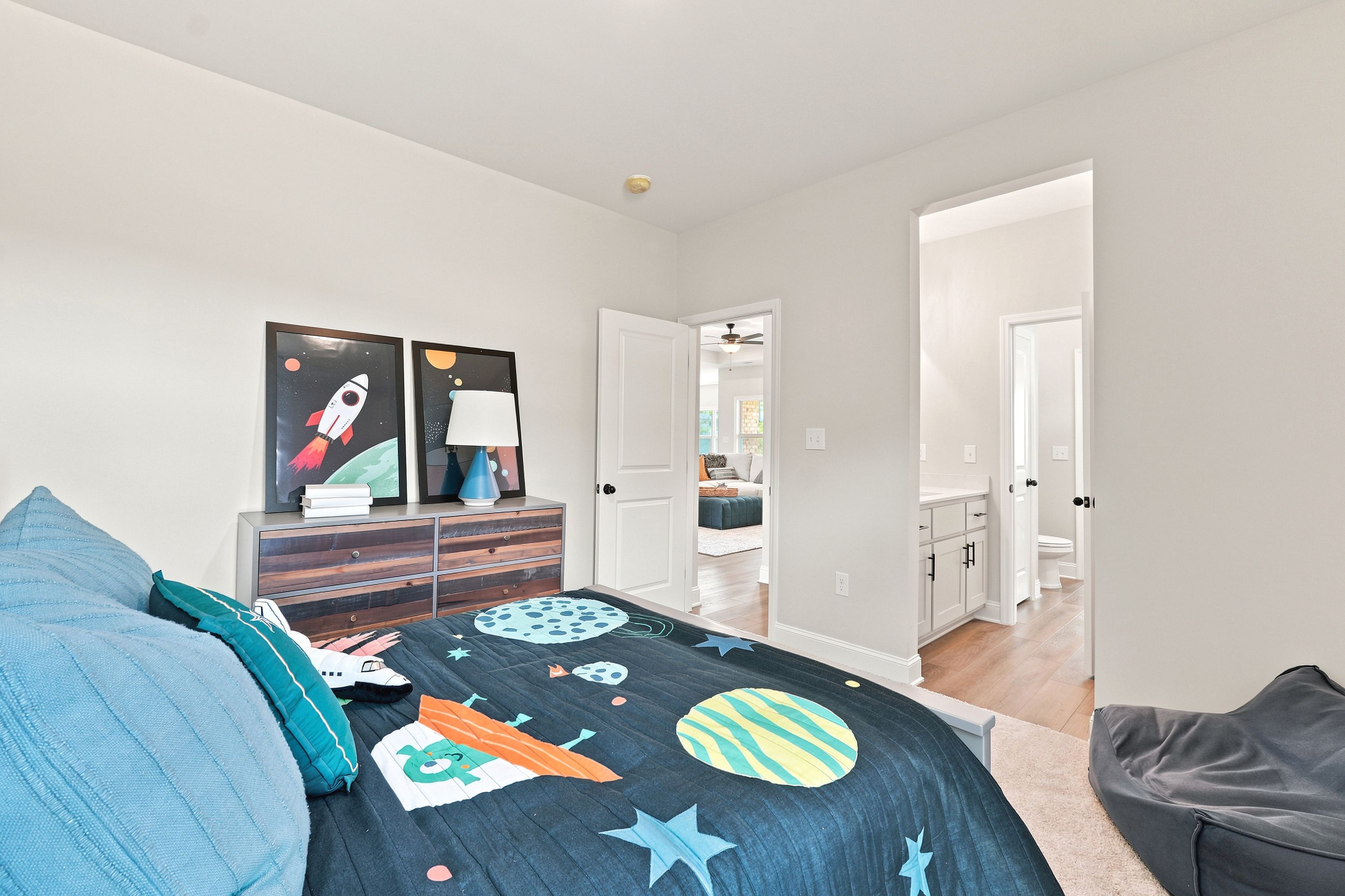 Space-themed kids' bedroom at Riverton Preserve in Huntsville, AL by Davidson Homes with en suite bathroom.