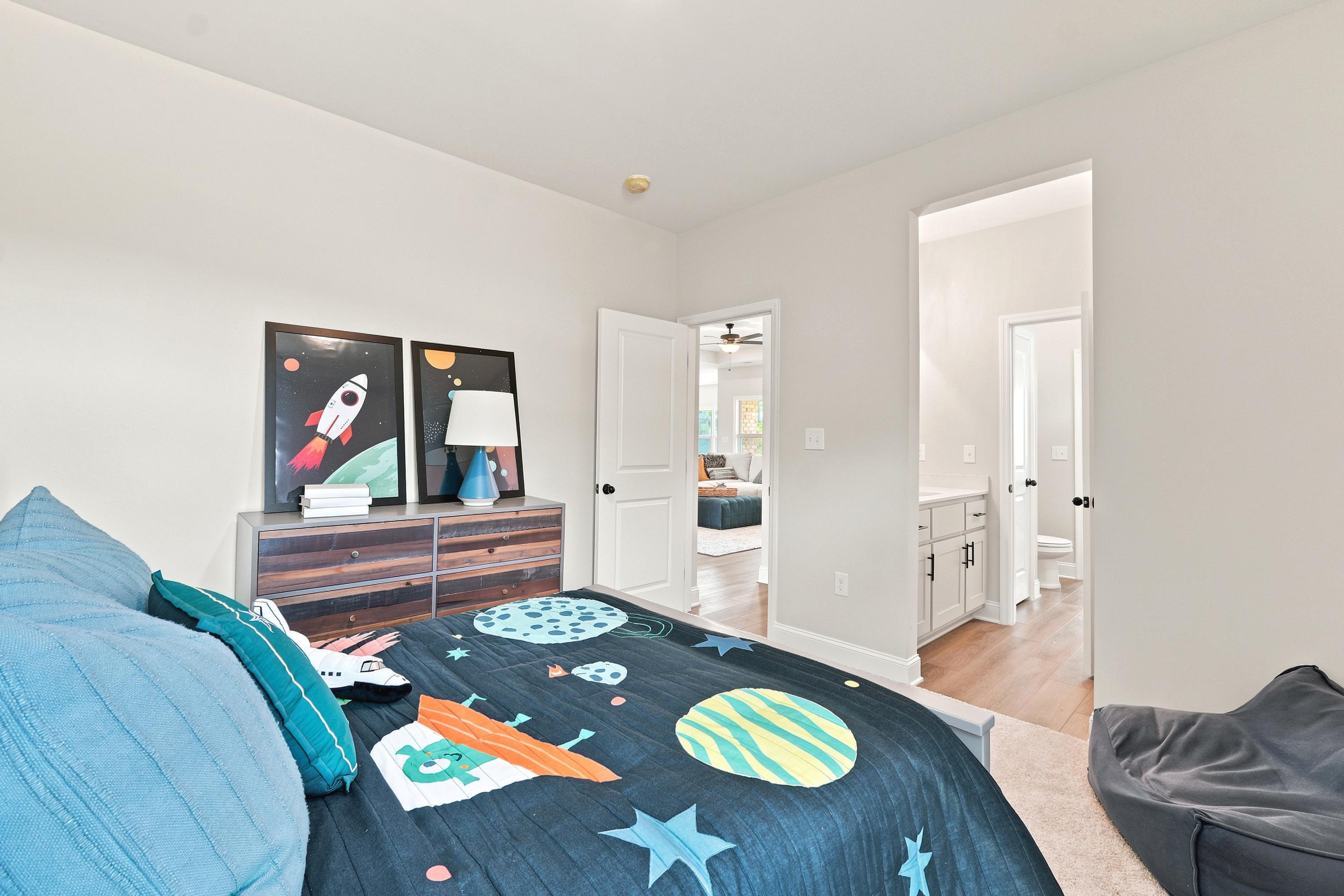 Space-themed kids' bedroom at Riverton Preserve in Huntsville, AL by Davidson Homes with en suite bathroom.