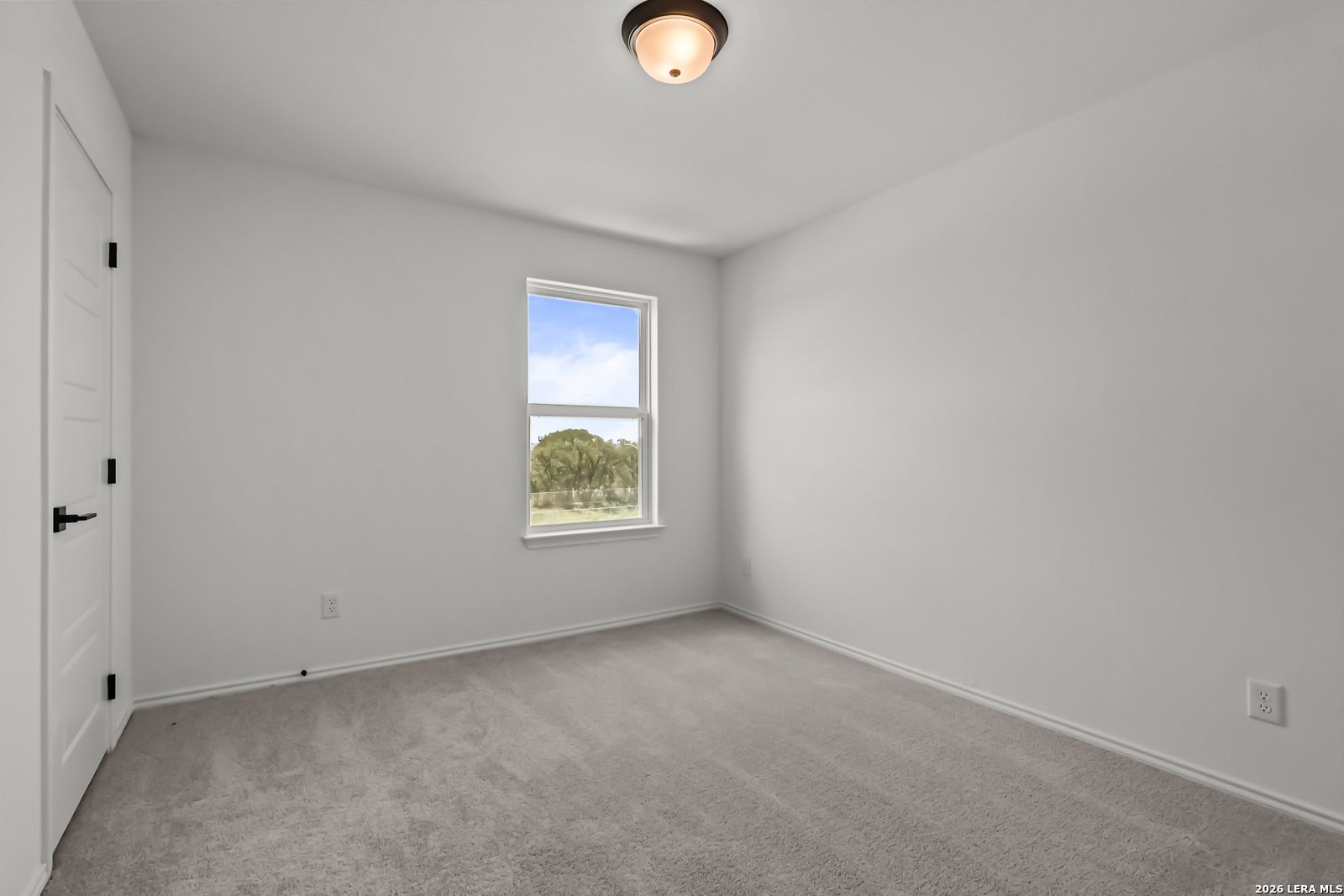 Bright, carpeted secondary bedroom in The Florence B floor plan at Meadows at Oak Creek, San Antonio, Texas.