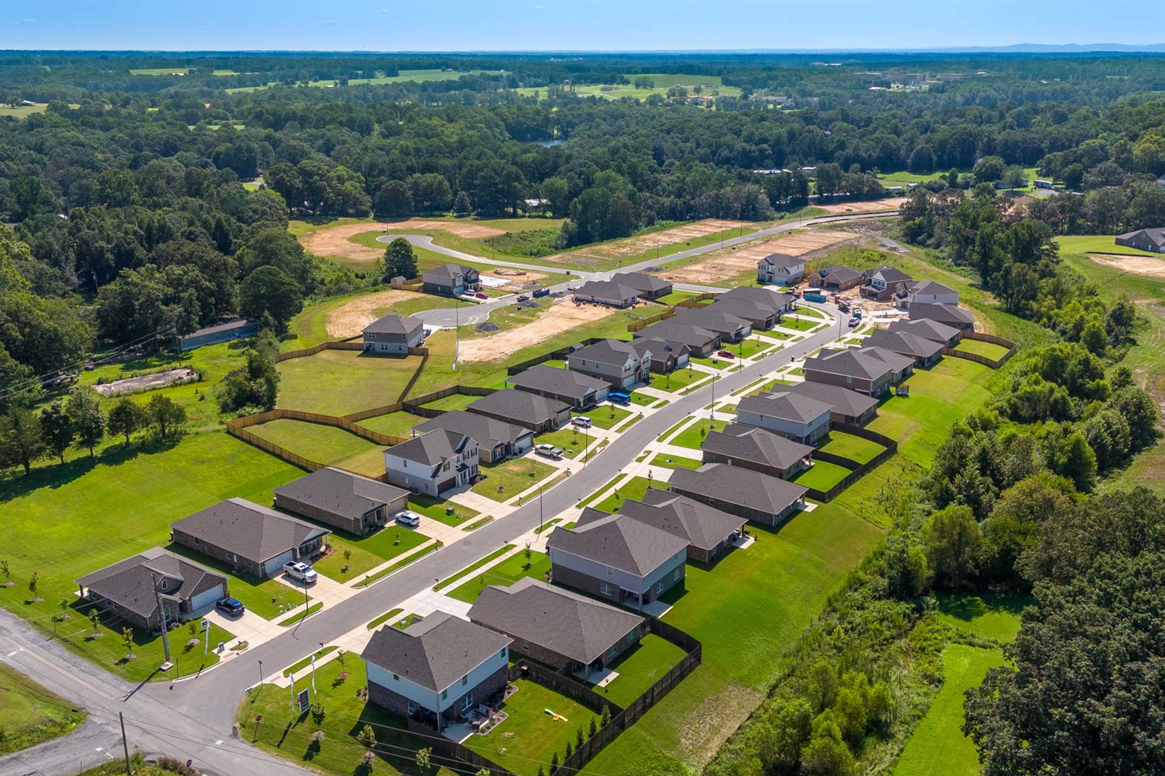 Aerial view of new homes and construction sites at The Reserve at North Ridge in Cullman Alabama amid green lawns and woods