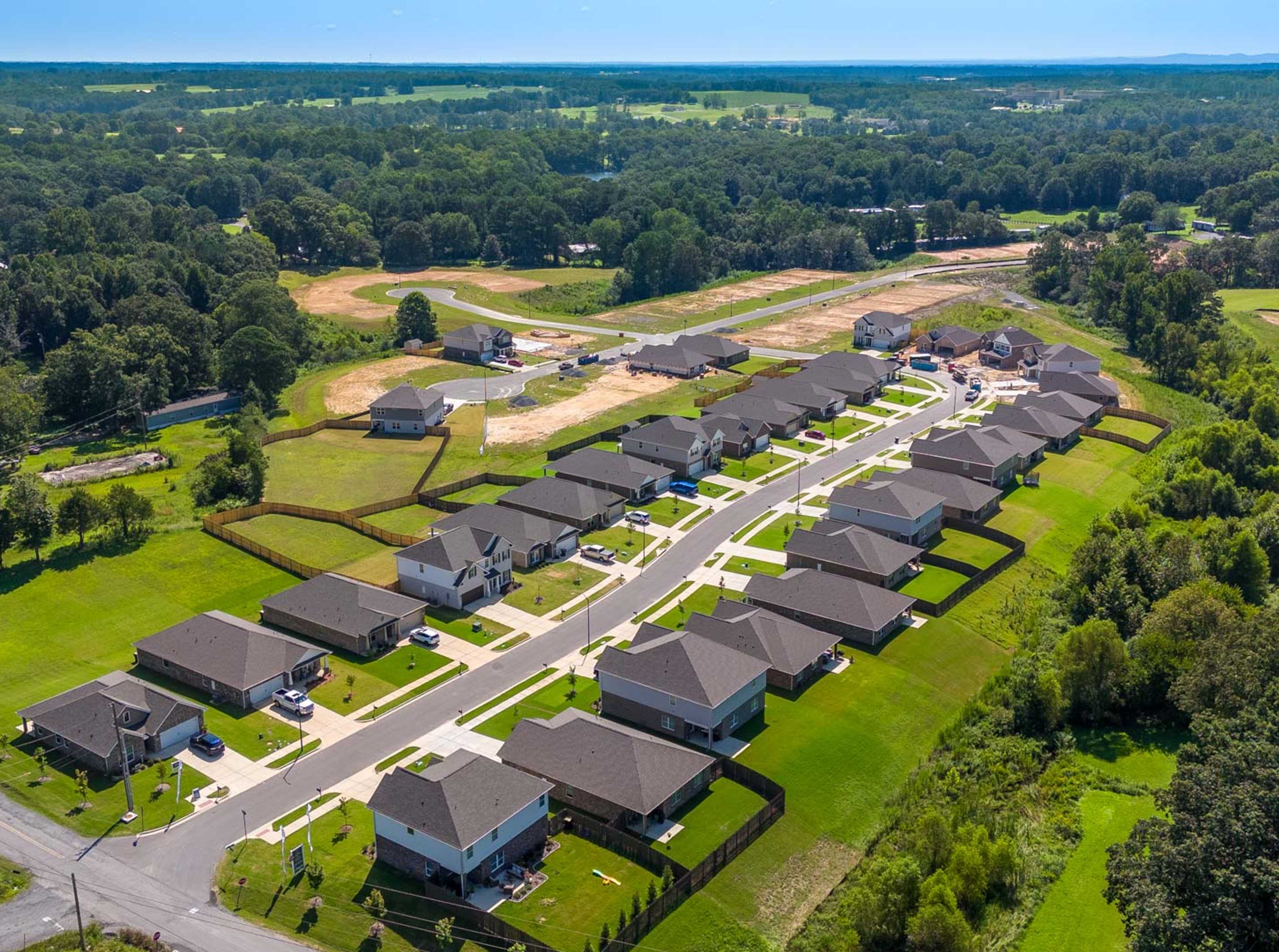 Aerial view of new single-family homes at The Reserve at North Ridge in Cullman Alabama amid lush green lawns and wooded surroundings
