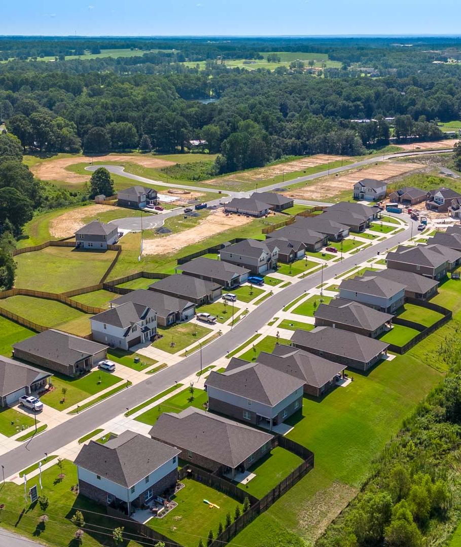 Aerial view of new single-family homes at The Reserve at North Ridge in Cullman Alabama amid lush green lawns and wooded surroundings