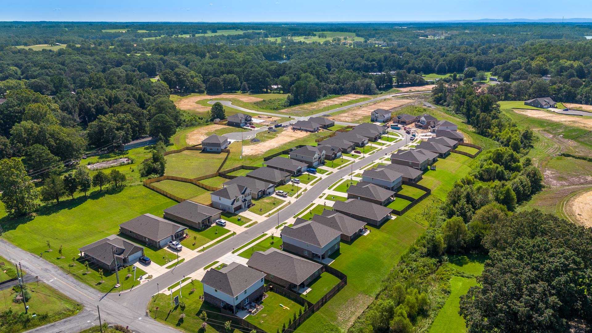 Aerial view of new single-family homes at The Reserve at North Ridge in Cullman Alabama amid lush green lawns and wooded surroundings