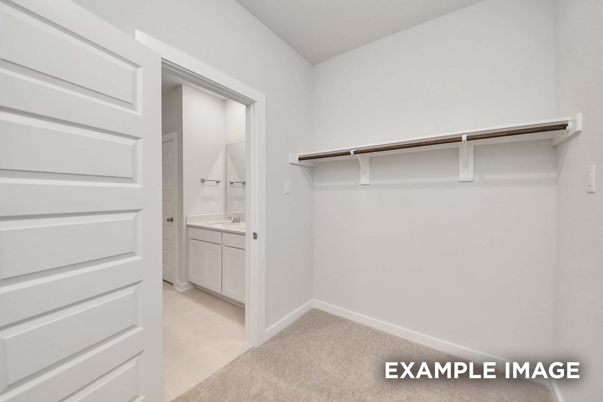 Spacious master closet with shelf and hanging rod adjoining the master bath in The Blanco by Davidson Homes, Beasley, TX