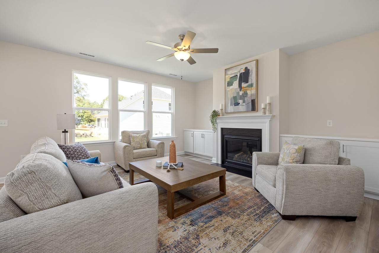 Bright, open-concept living room in The Chestnut featuring a cozy fireplace, built-in cabinetry, and modern furniture.