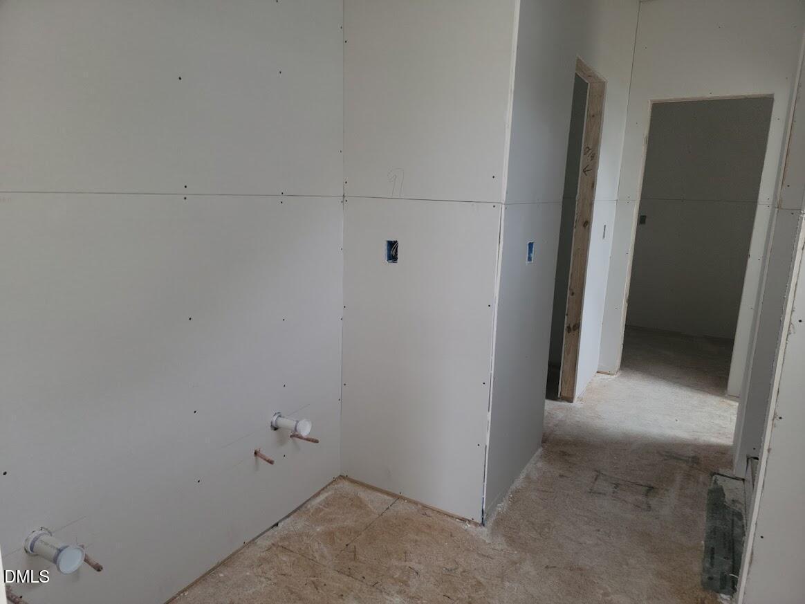 Framed hallway with exposed drywall, electrical outlets, and plumbing in under-construction 5-bedroom Davidson Homes Ashport G, Angier NC