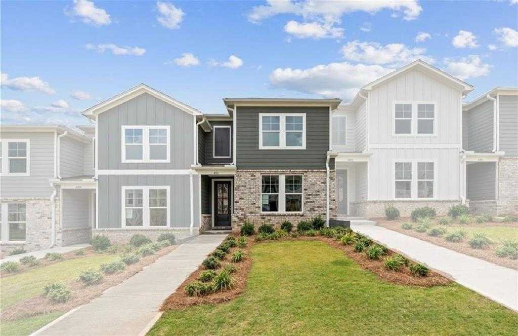 Modern 2-story gray townhome exterior with brick accents, landscaped yard, and walkway in Davidson Homes The Monroe A, Stegall Village, Emerson, GA