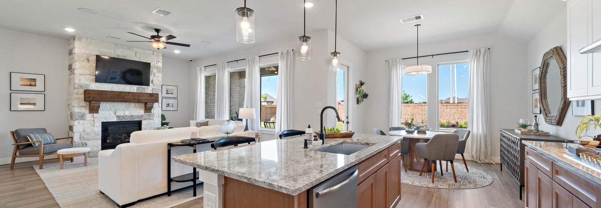 Open-concept kitchen and living room at Lago Mar in Texas City TX with stone fireplace, hardwood floors, granite island