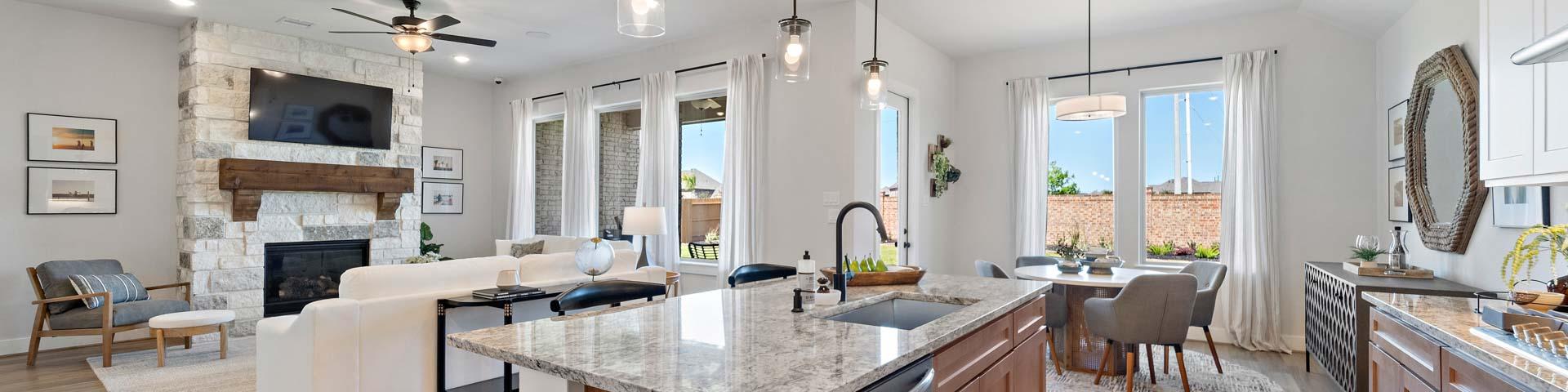 Open-concept kitchen and living room at Lago Mar in Texas City TX with stone fireplace, hardwood floors, granite island