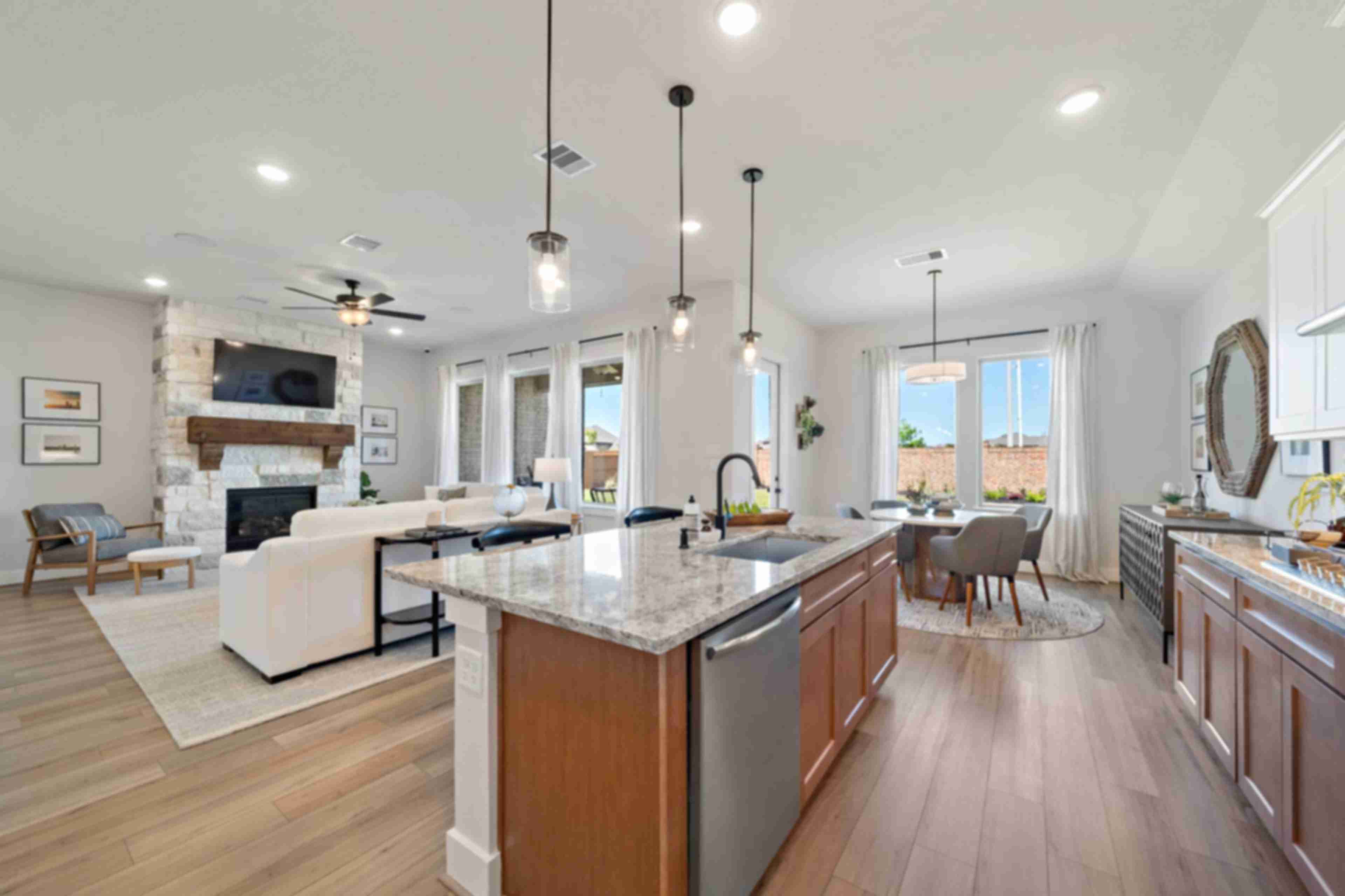 Open-concept kitchen and living room at Lago Mar in Texas City TX with stone fireplace, hardwood floors, granite island