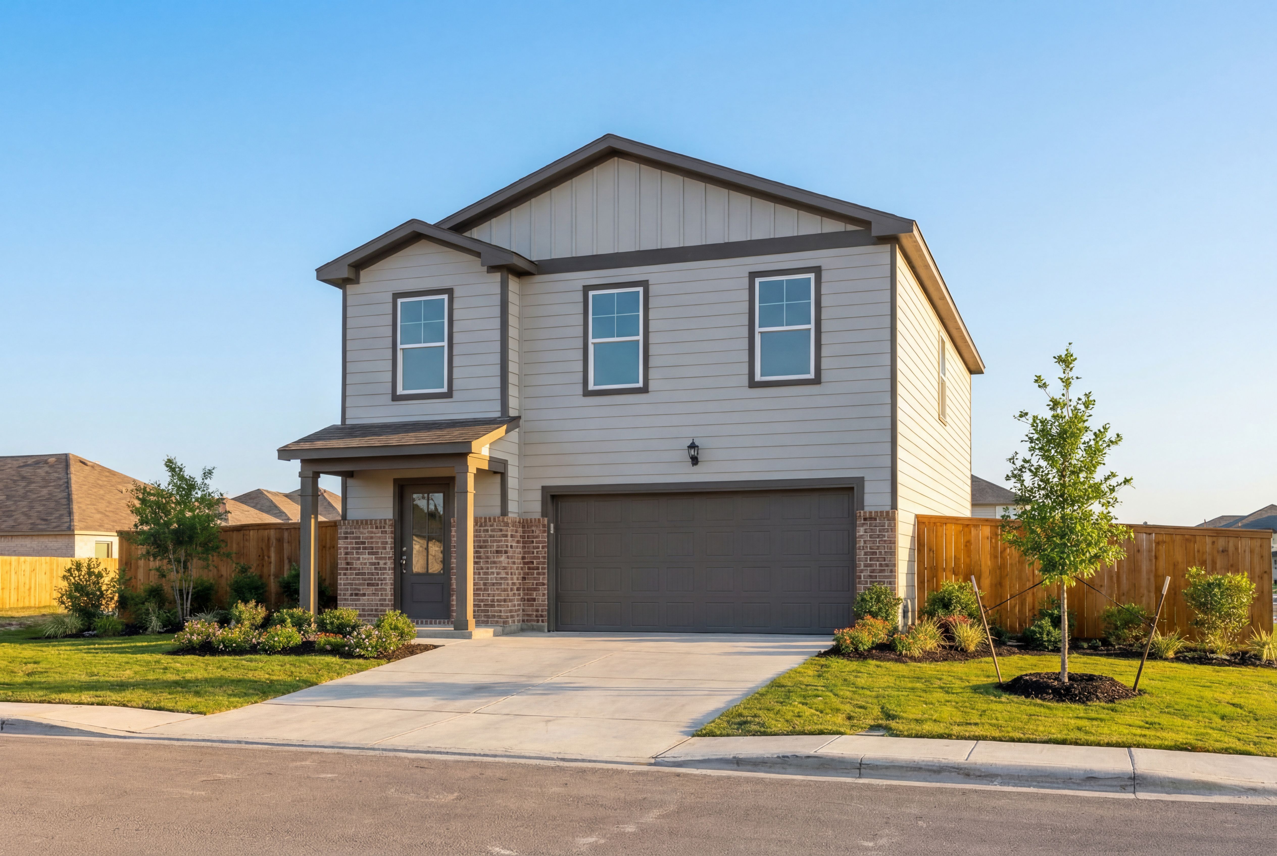 Two-story The Trinity B home by Davidson Homes in San Antonio with beige siding, brick accents, covered porch, and 2-car garage