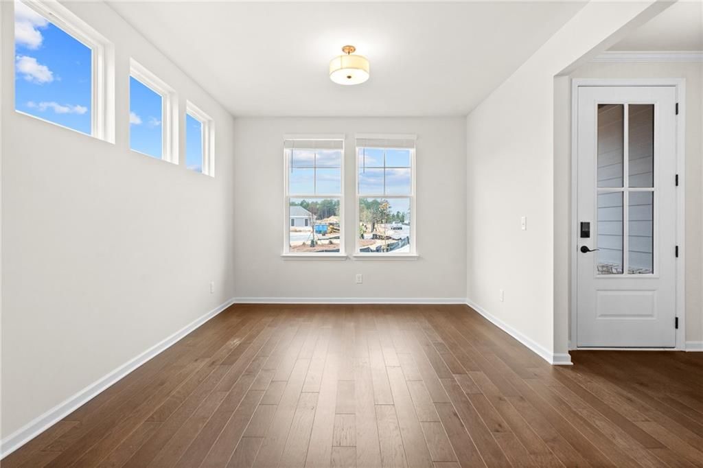 Bright dining room with large windows, hardwood floors, and chandelier in The Glenwood A, Davidson Homes, Loganville, GA