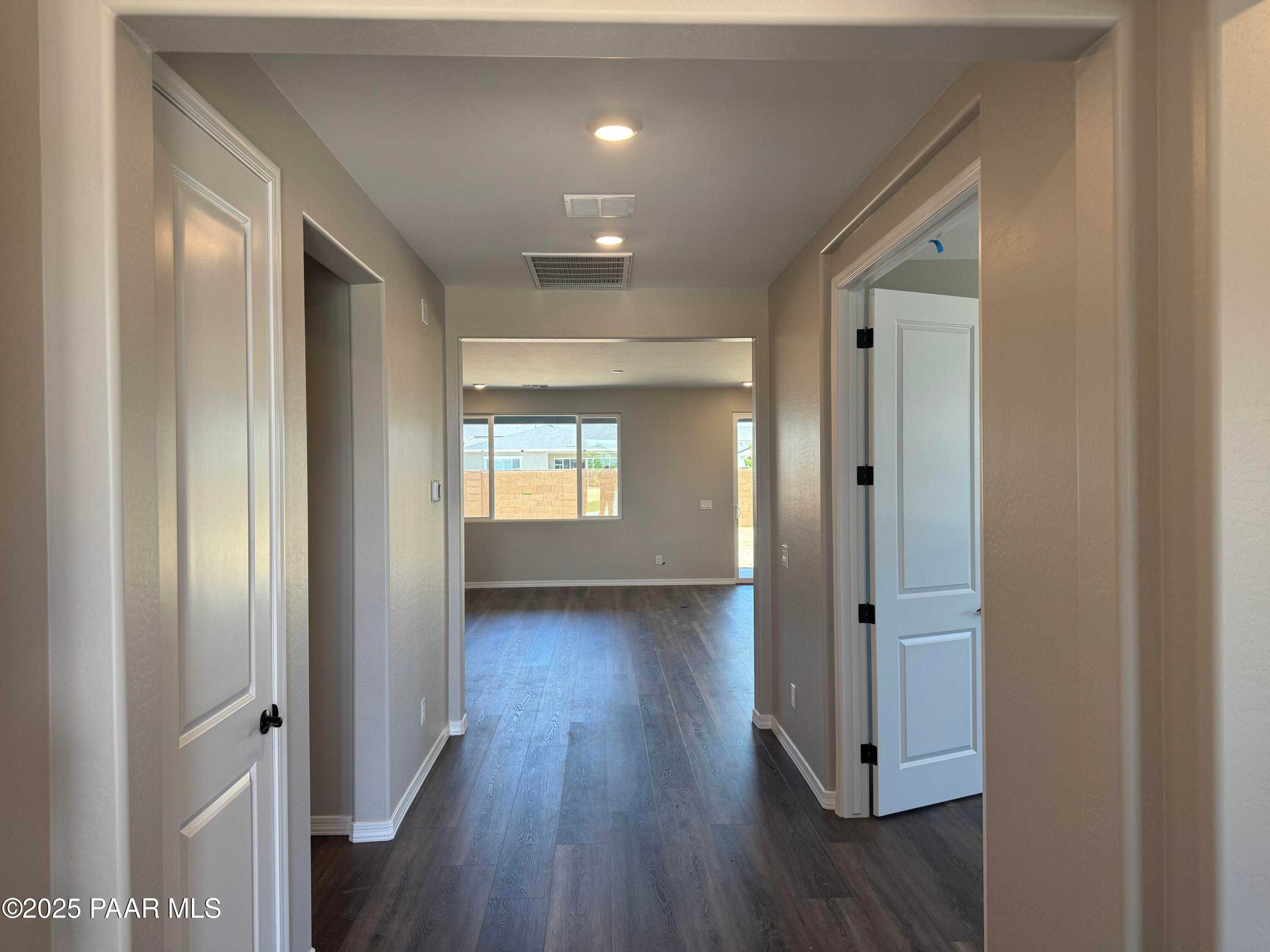 Spacious hallway with dark hardwood floors, white doors, and recessed lighting in The Durango II A home, Westwood, Prescott, Arizona