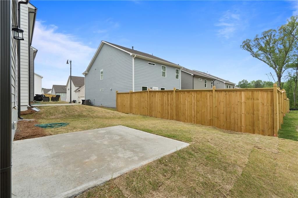 Private fenced backyard with concrete patio and grassy lawn in two-story Cary B home by Davidson Homes, Kennesaw, Georgia