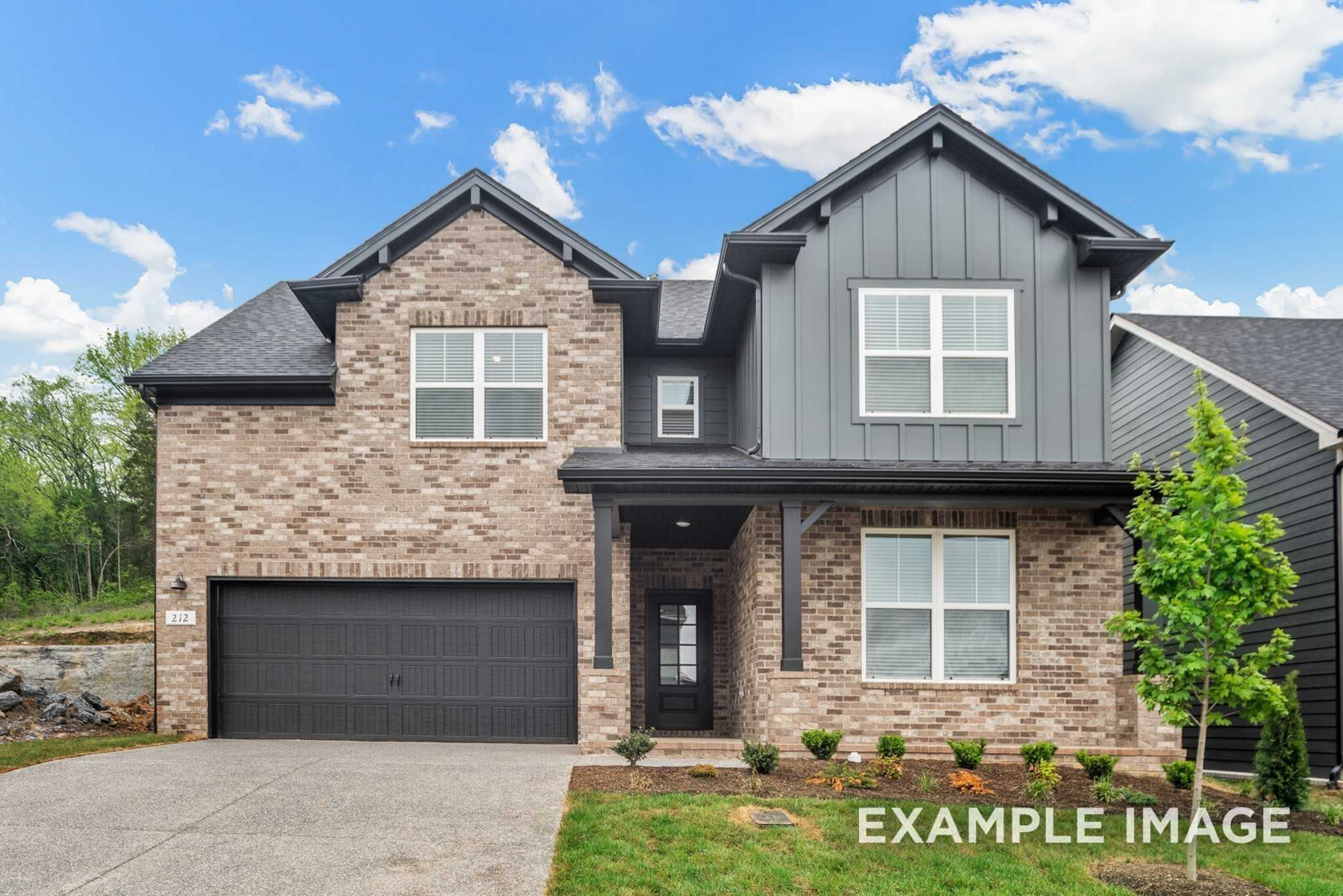 Two-story brick and siding home with two-car garage and front porch in Woods Crossing, Gallatin, Tennessee