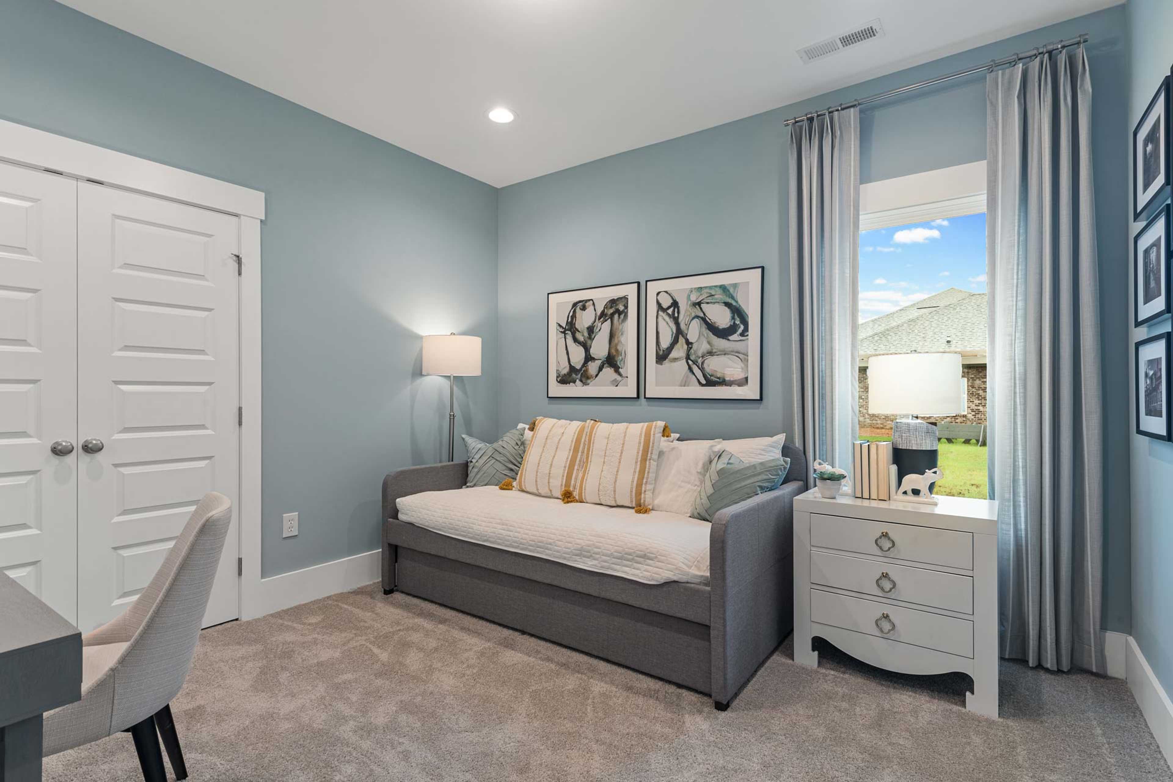 Cozy soft blue bedroom at Monteagle Cove in Owens Cross Roads Alabama with daybed, desk, abstract art and window view