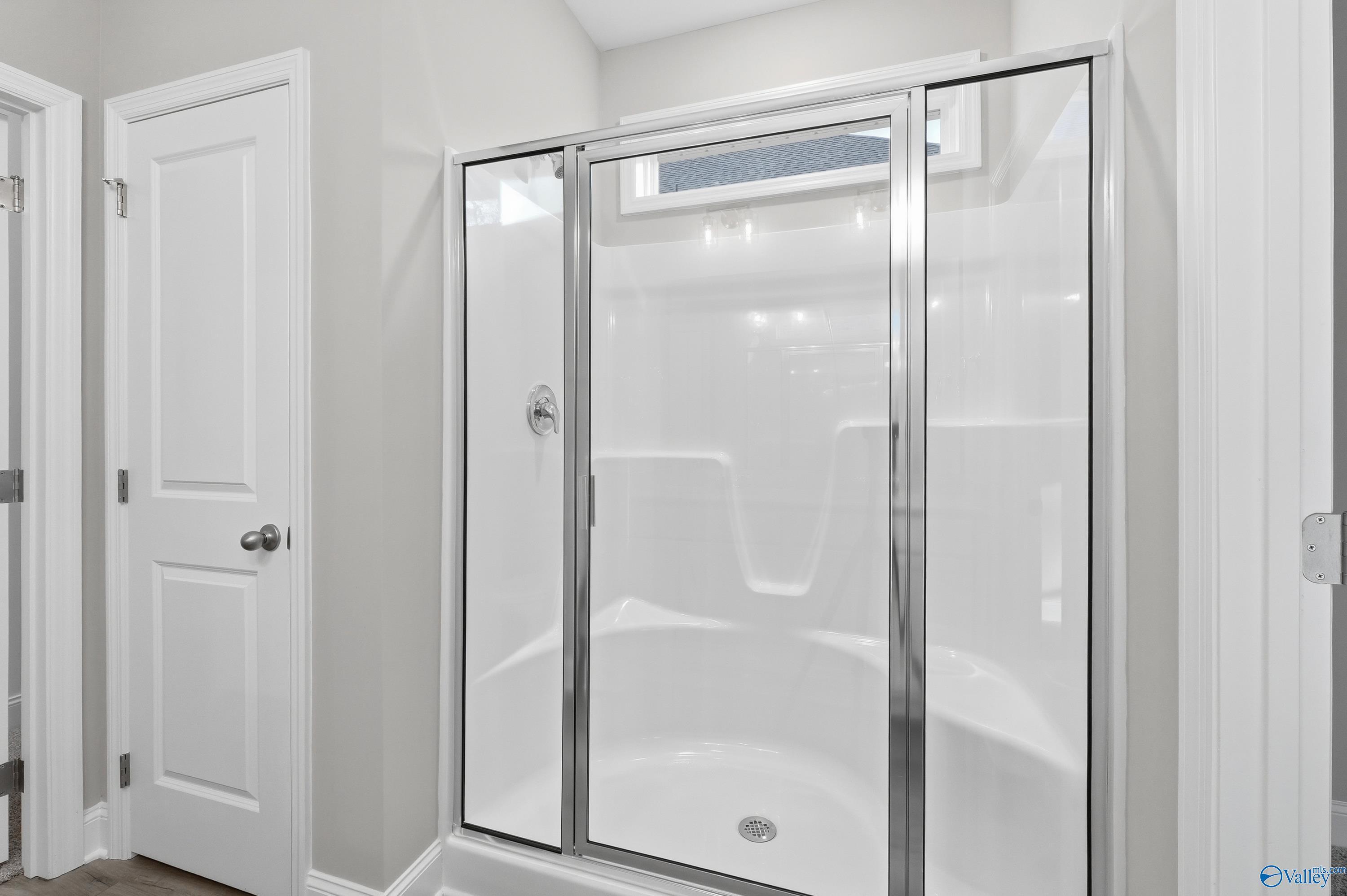 Modern frameless glass shower with white subway tiles in master bath of Davidson Homes The Asheville, Arab, Alabama