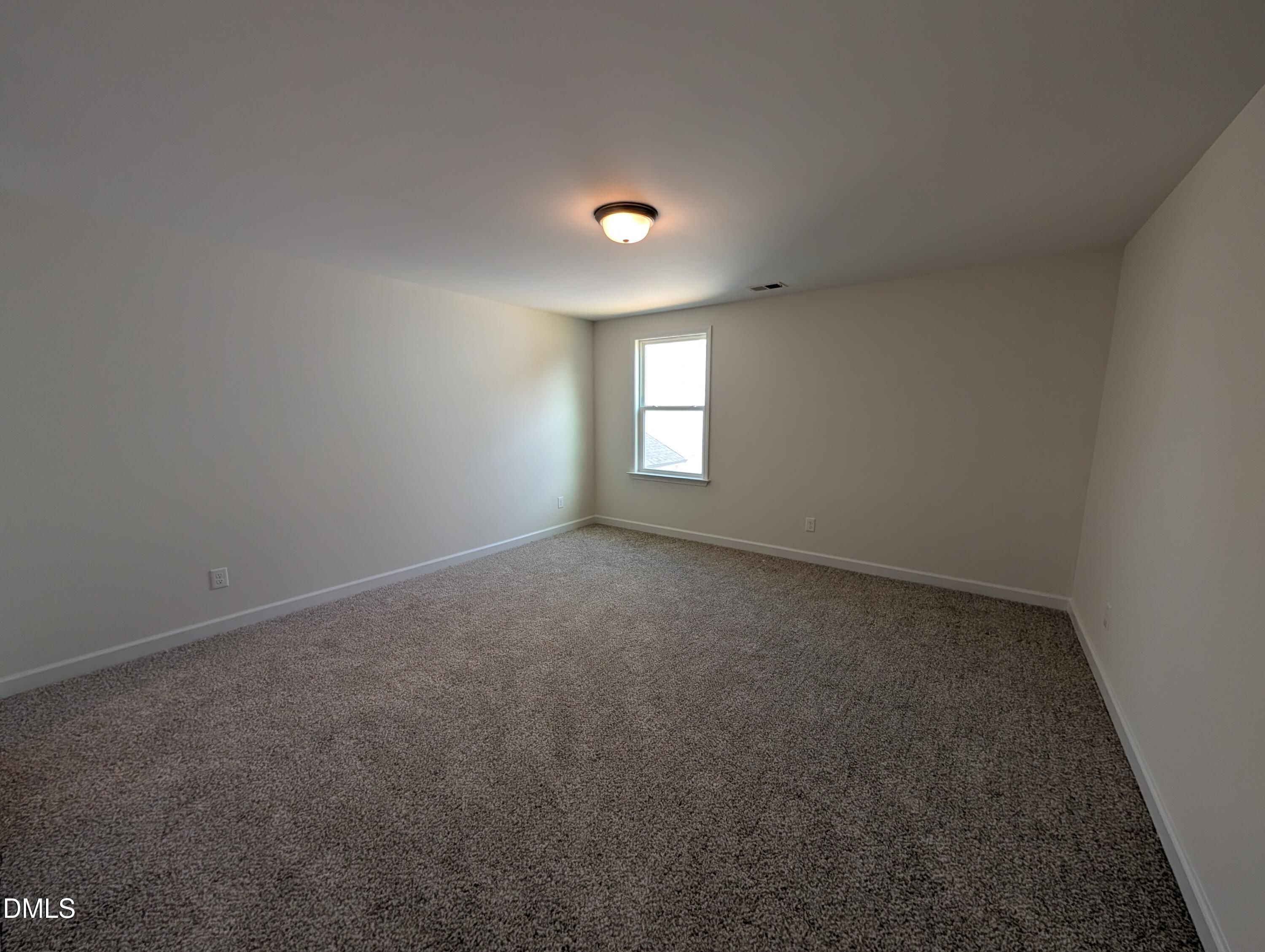 Spacious carpeted bedroom with natural light in Davidson Homes Magnolia A floor plan at Wendell Ridge, Wendell, North Carolina