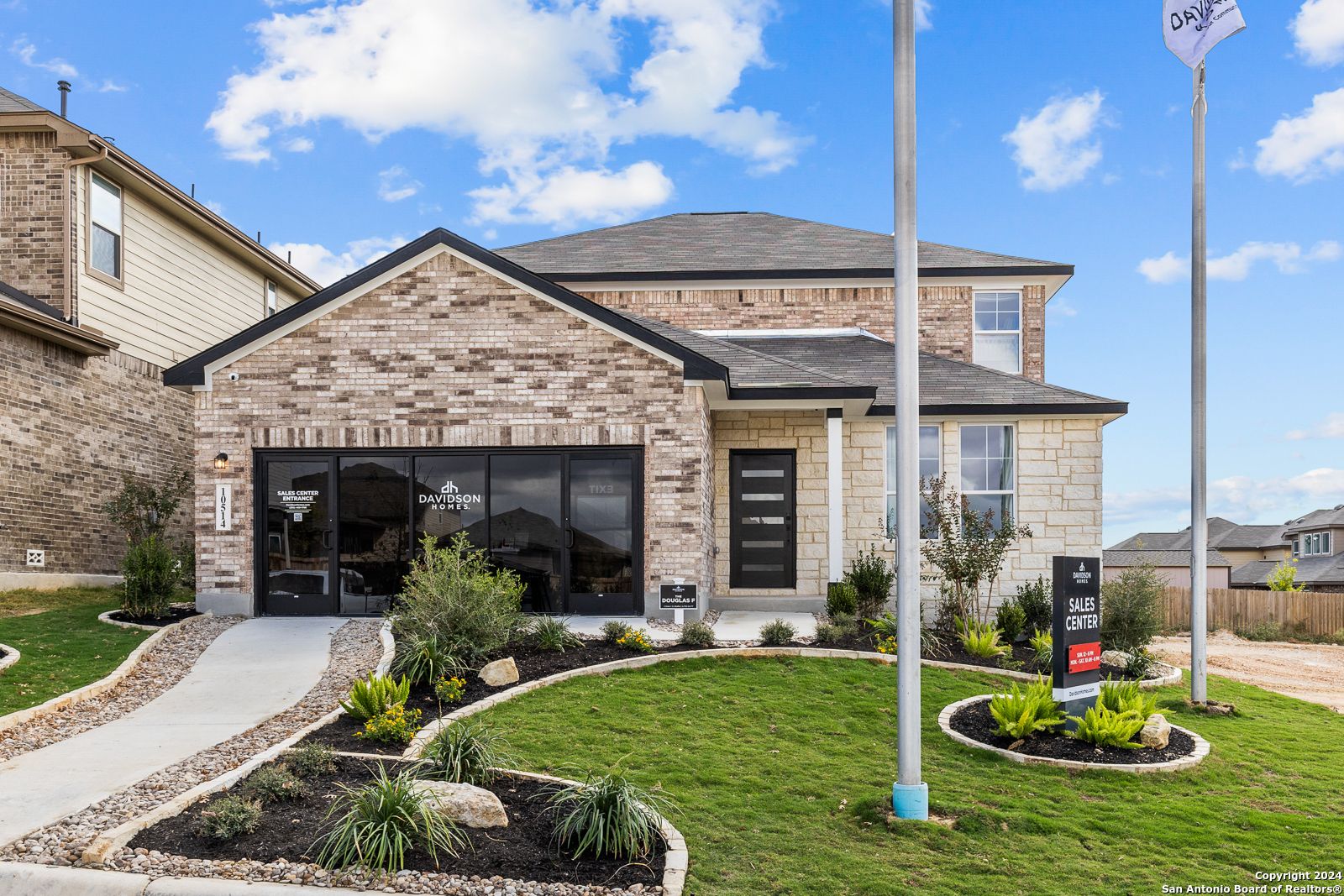 Modern 2-story brick home with 2-car garage, landscaped yard, and for-sale sign in Bricewood, San Antonio, Texas - Davidson Homes Douglas F