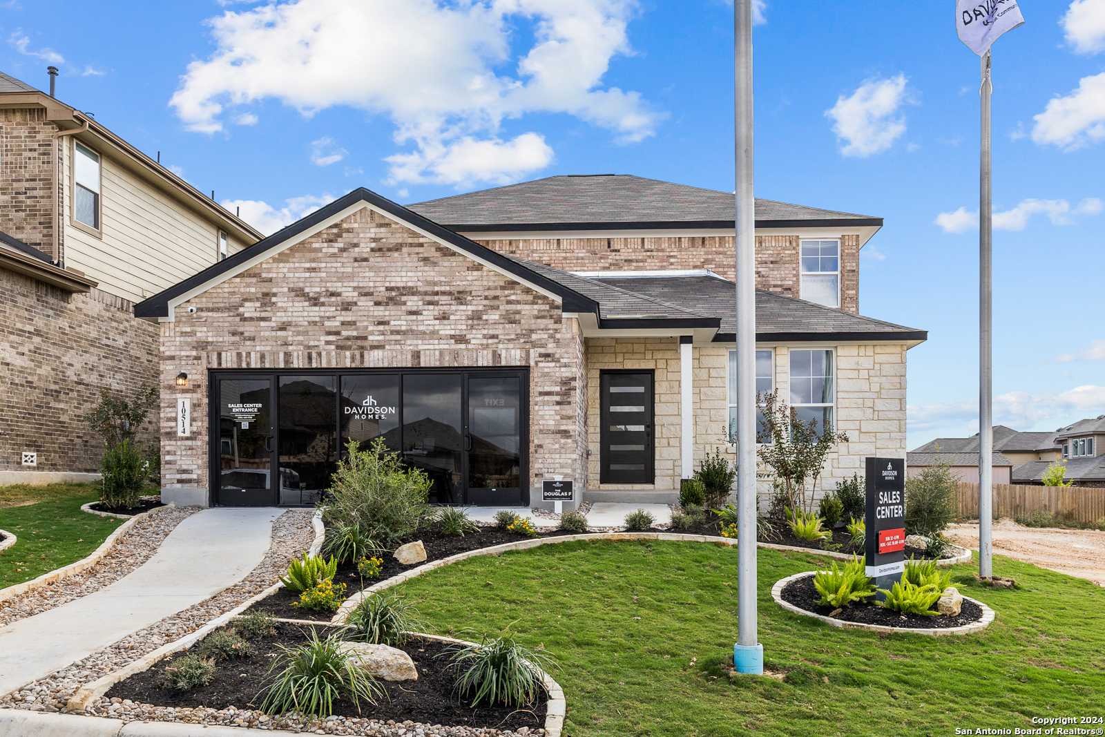 Modern 2-story brick home with 2-car garage, landscaped yard, and for-sale sign in Bricewood, San Antonio, Texas - Davidson Homes Douglas F