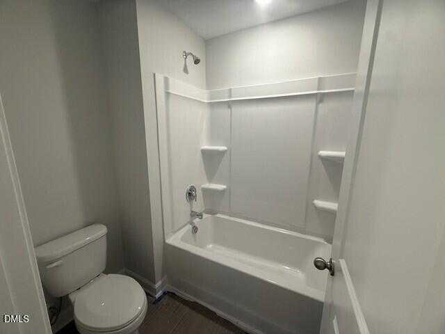 Modern bathroom with white tub, tiled shower, and toilet in 4-bedroom Davidson Homes The Preston C, Lillington, NC
