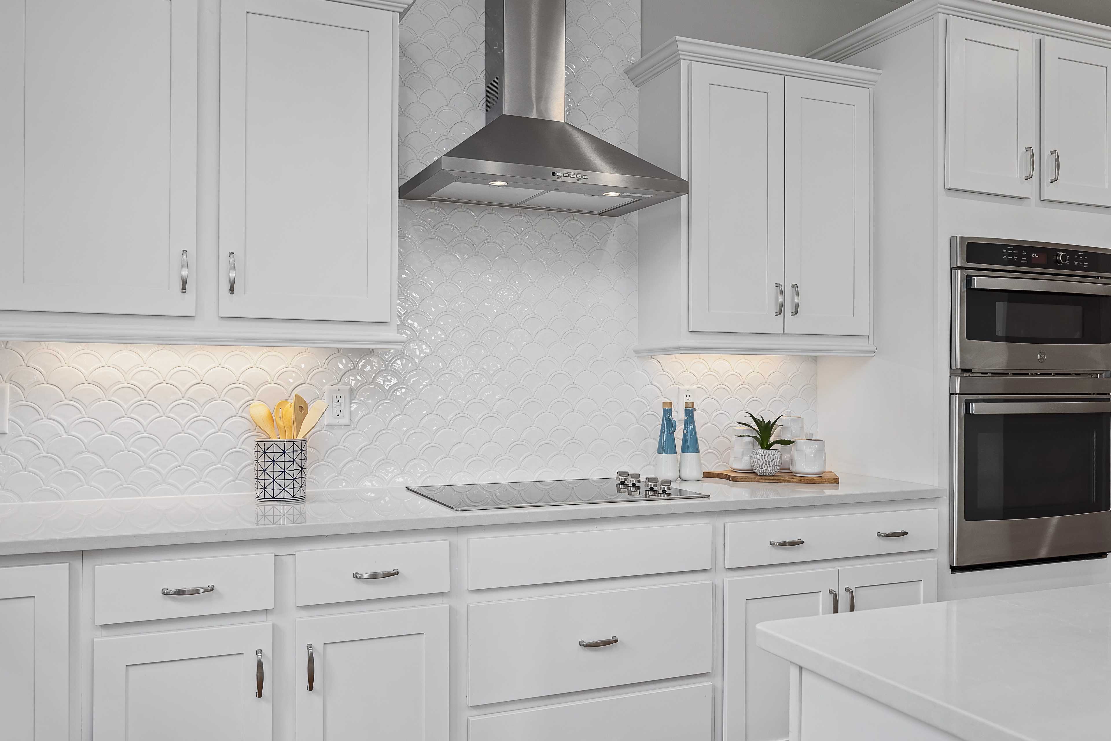 Modern white kitchen with shaker cabinets, stainless steel appliances, subway tile backsplash at Woodland Crossing in Zebulon NC