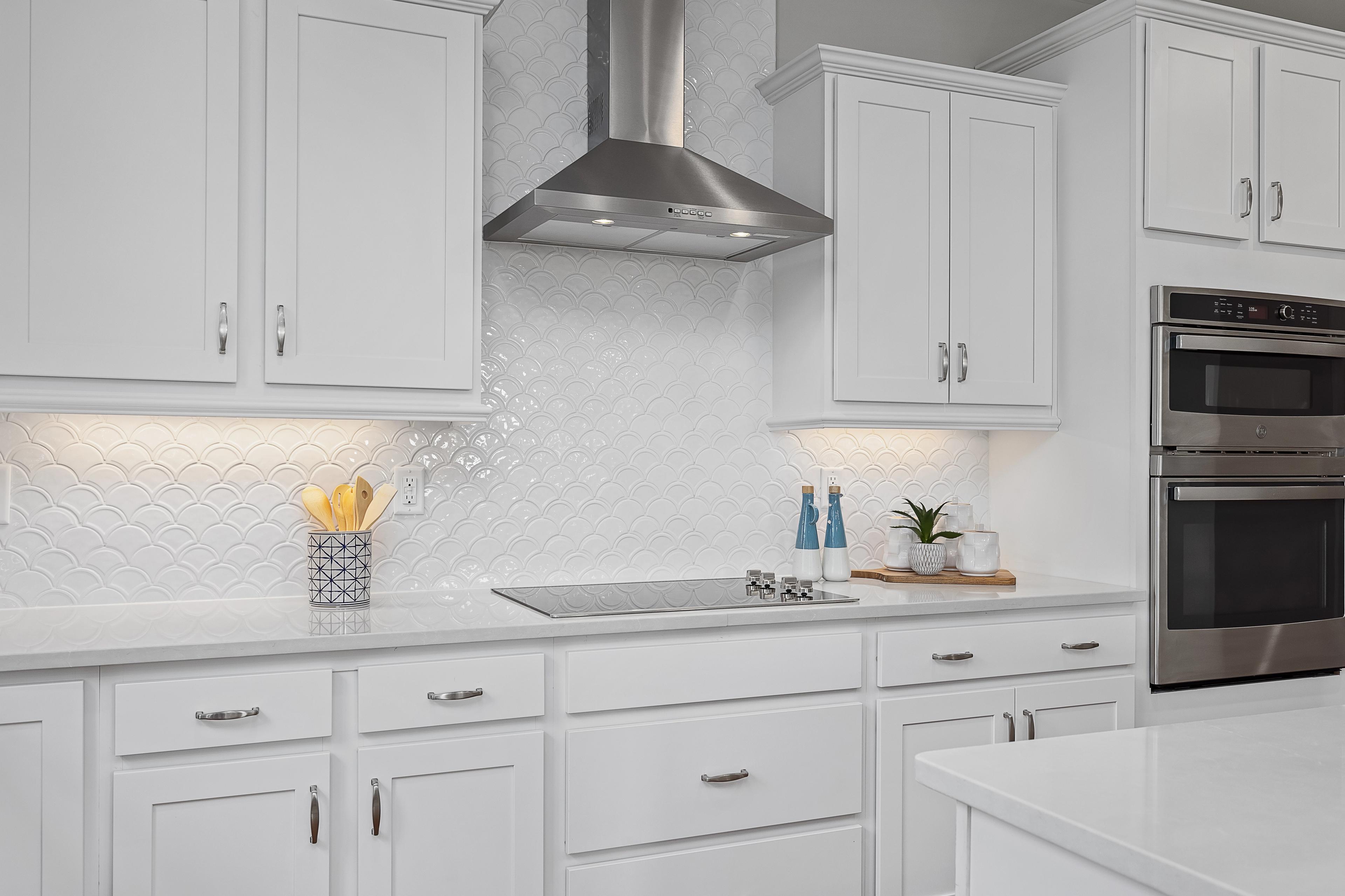 Modern white kitchen with shaker cabinets, stainless steel appliances, subway tile backsplash at Woodland Crossing in Zebulon NC