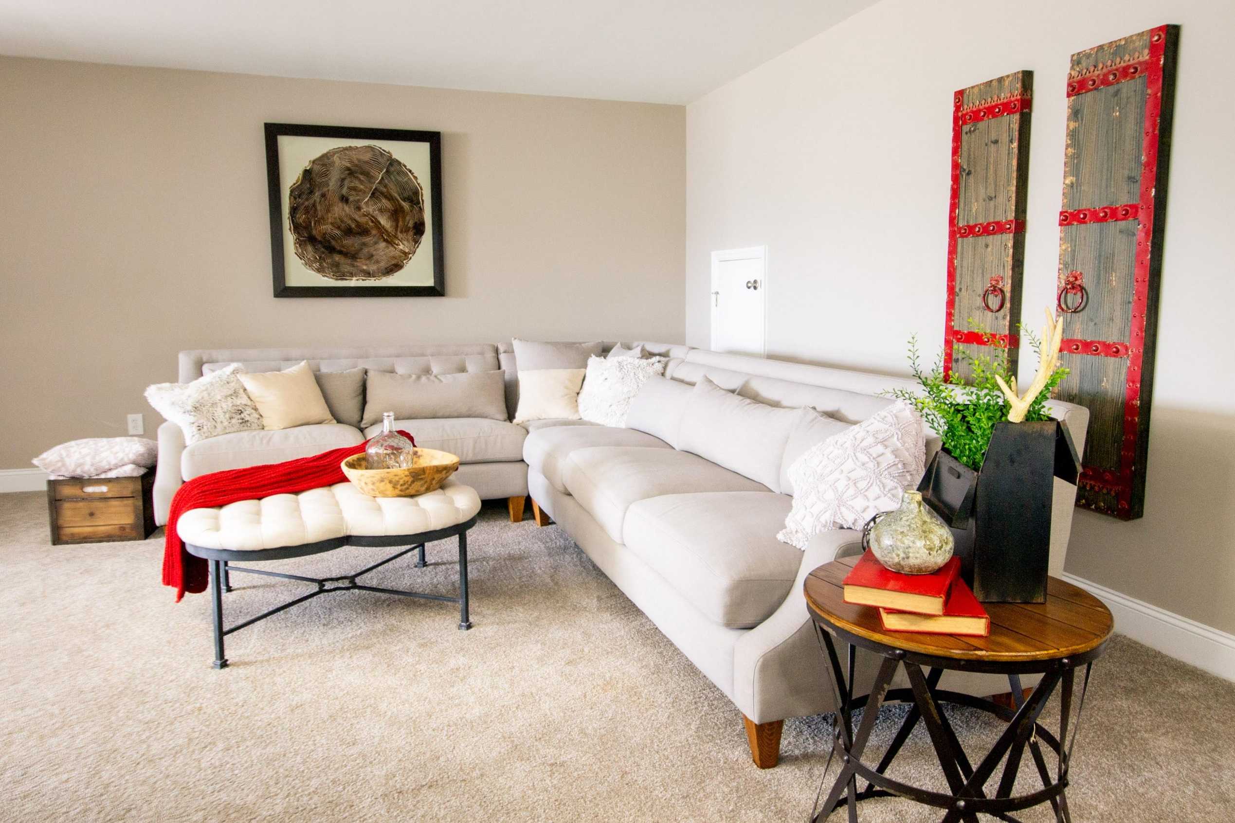 Cozy gray L-shaped sectional in Bakers Farm living room, Priceville Alabama with abstract wall art, plants, and neutral decor