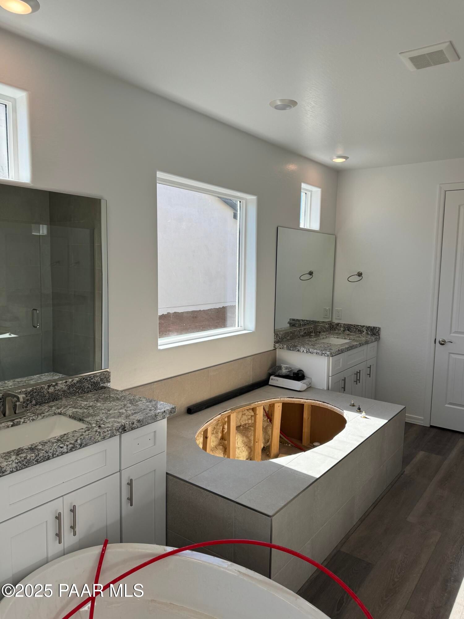 Modern master bathroom featuring double granite vanity, large window, and oval soaking tub in Davidson Homes Sunrise II A, Prescott AZ