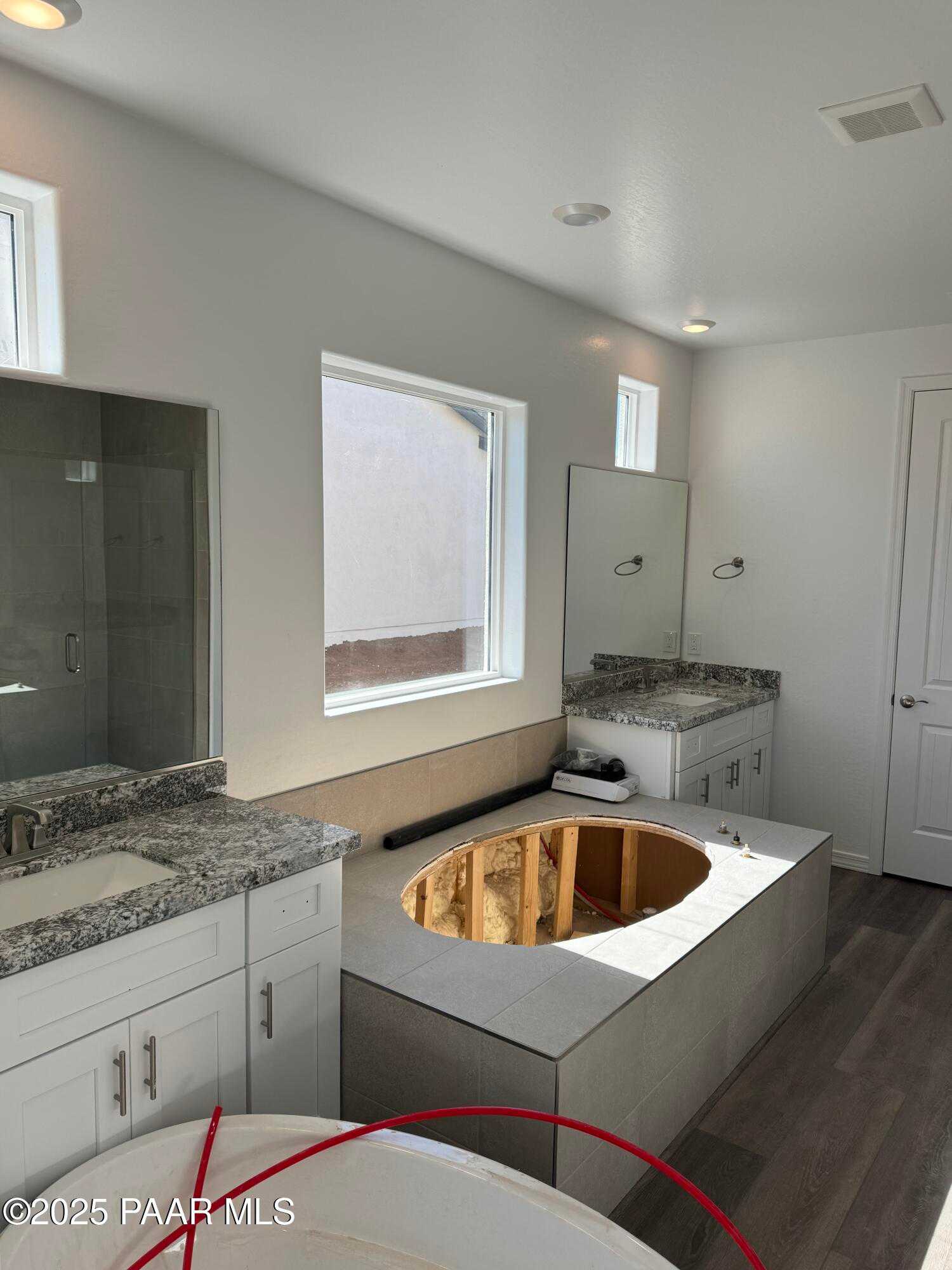 Modern master bathroom featuring double granite vanity, large window, and oval soaking tub in Davidson Homes Sunrise II A, Prescott AZ