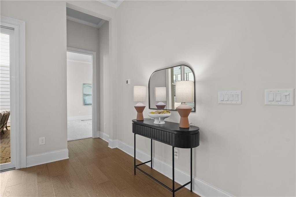 Elegant entry foyer with black console table, arched mirror, terracotta lamps in Davidson Homes The Seaside B, Woodstock, GA