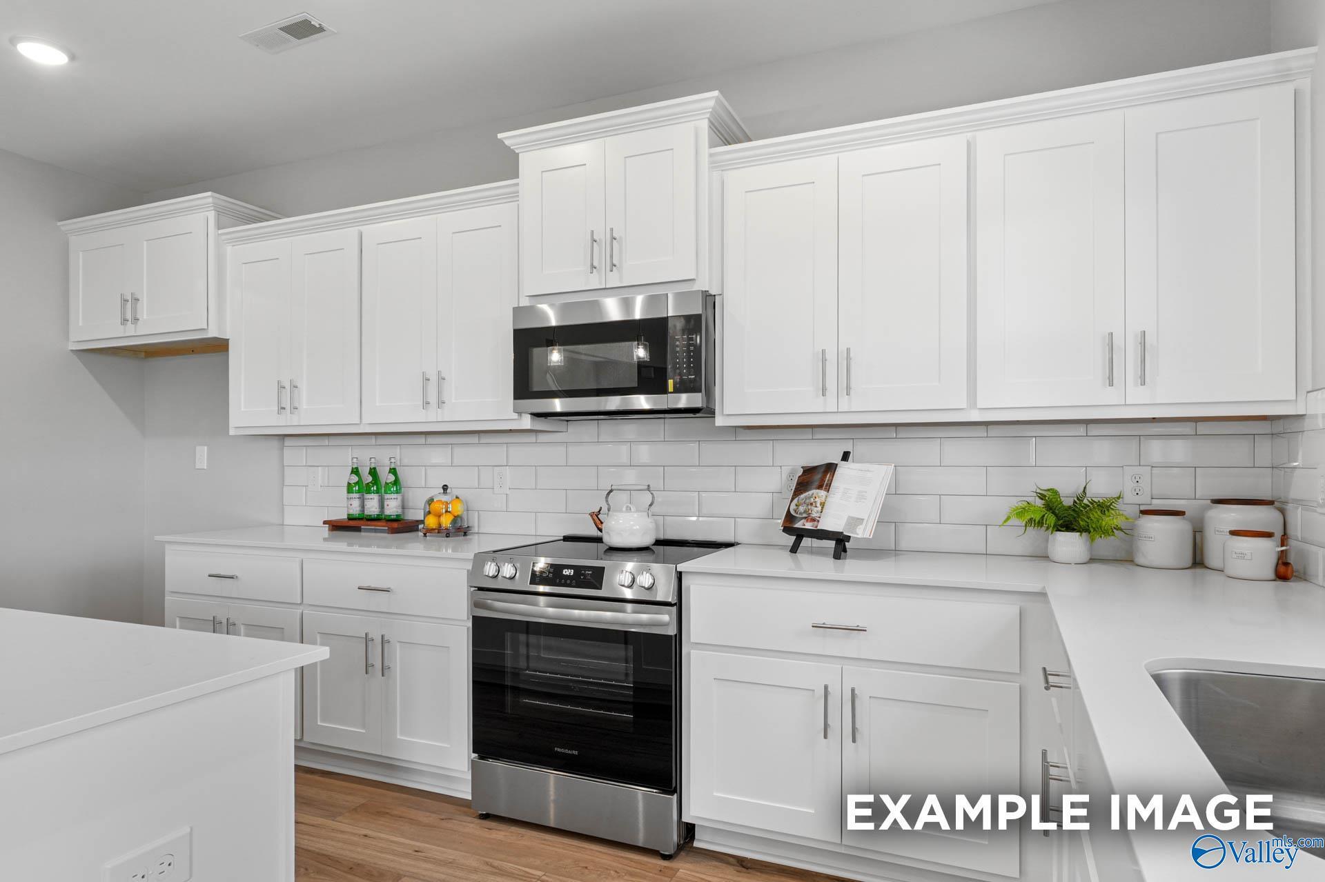 Modern white kitchen with shaker cabinets, stainless steel range, subway tile backsplash in Davidson Homes Chelsea B, Toney AL
