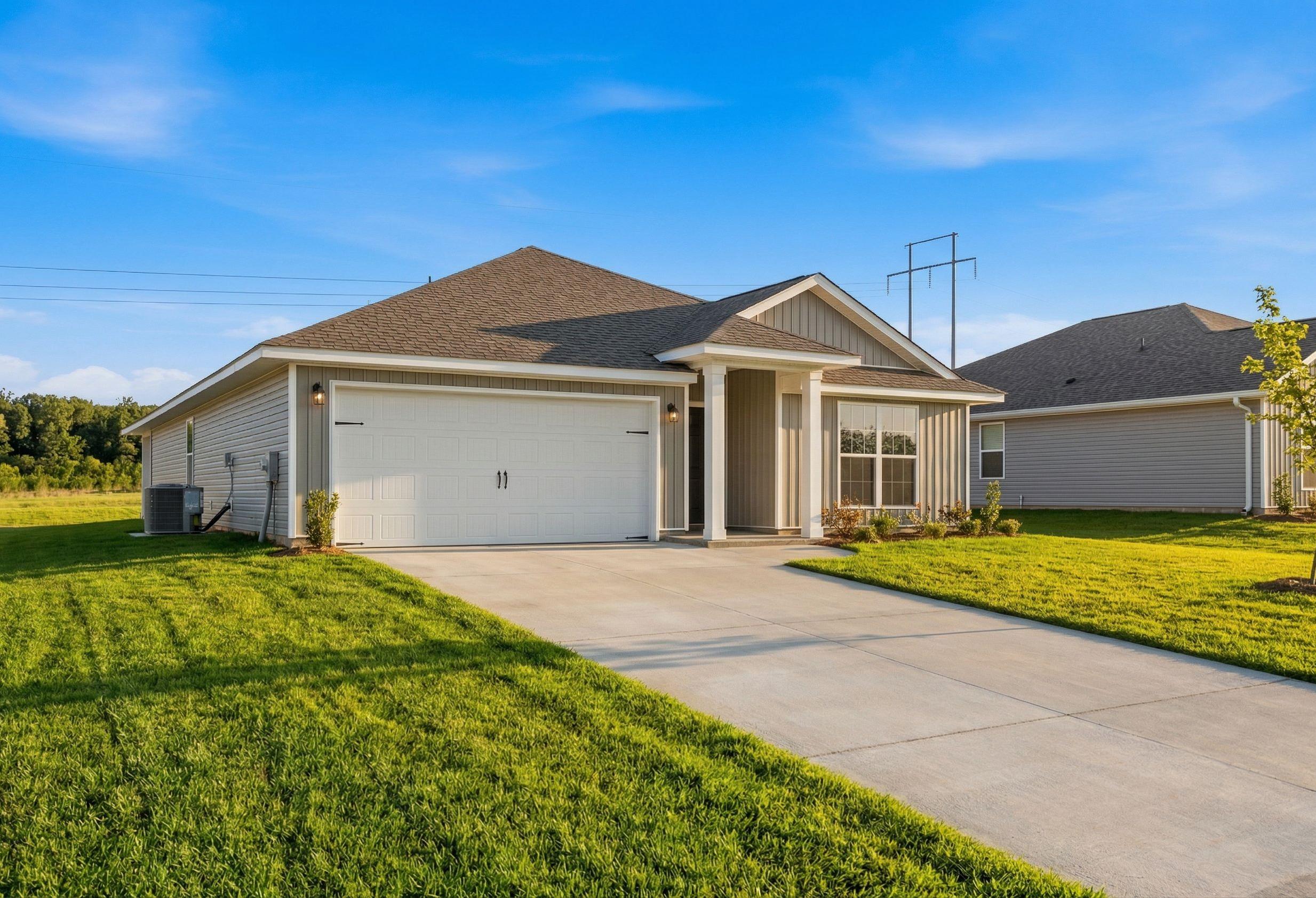 Modern single-story The Daphne V home elevation with beige siding, shingled roof, 2-car garage, and landscaped yard in Meridianville
