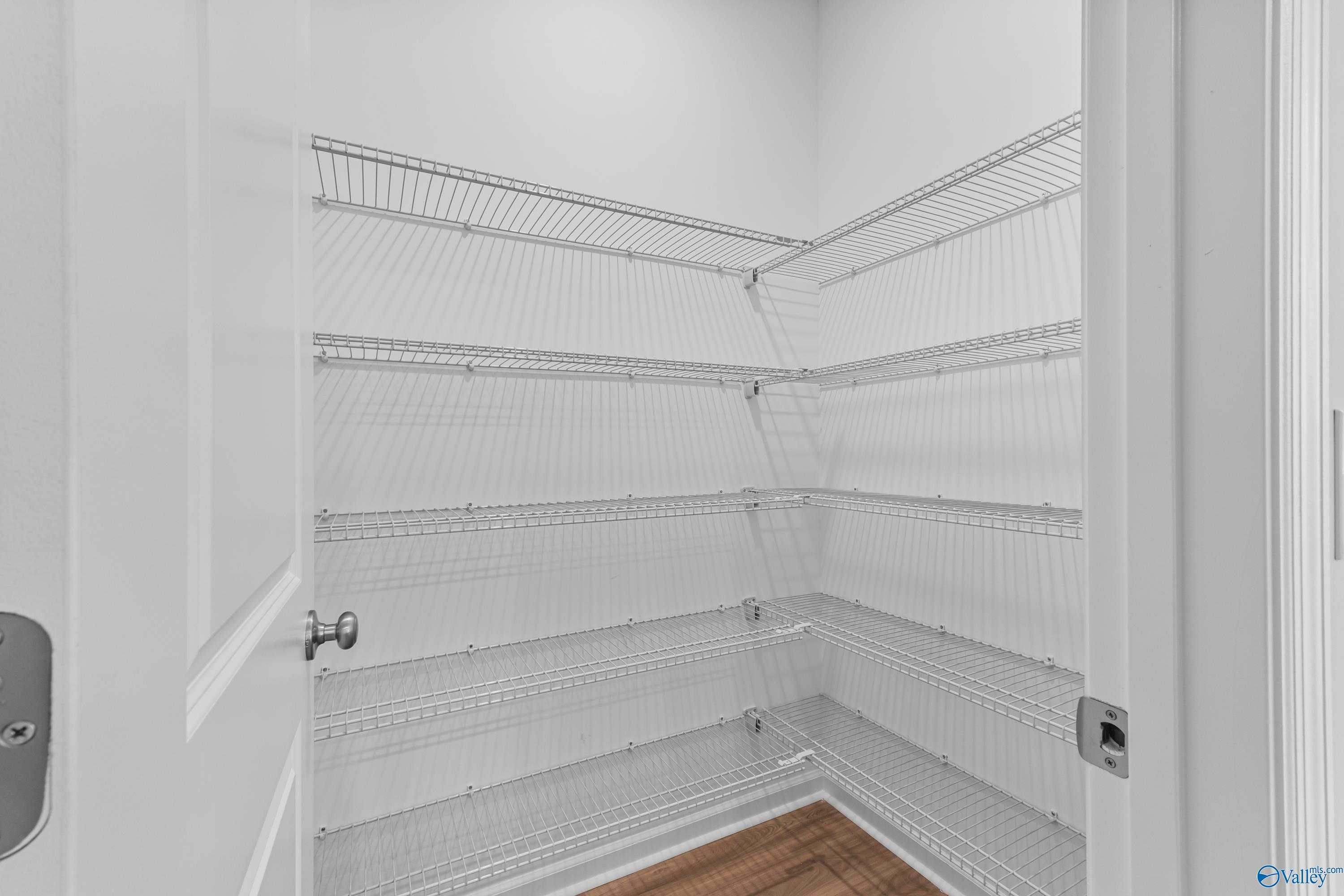 Spacious corner walk-in closet with white wire shelving in The Aurora floor plan by Davidson Homes, Fayetteville, Tennessee