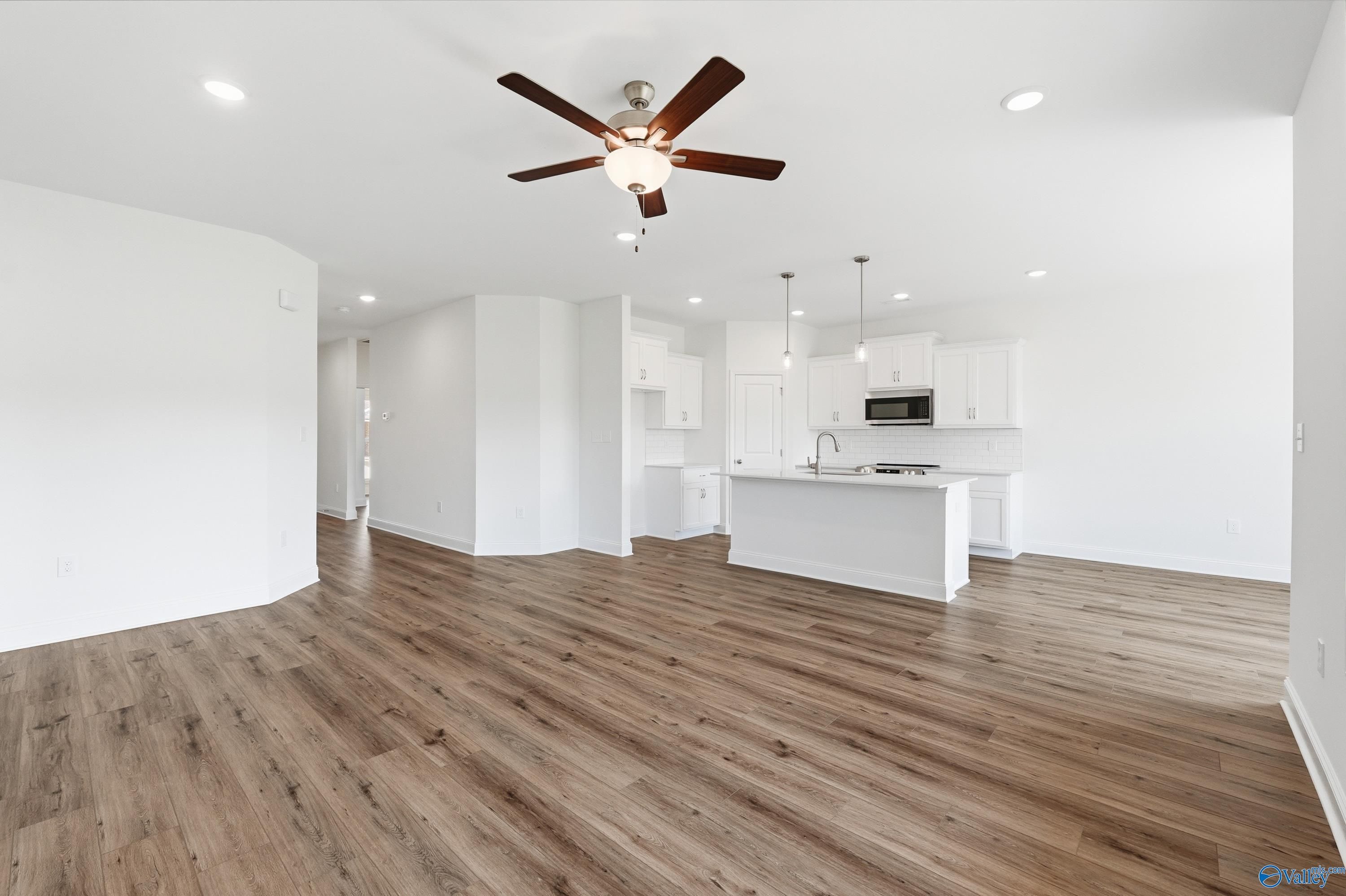 Open-concept living room and kitchen with white cabinets in The Asheville floor plan, Jaguar Hills, Huntsville, Alabama.