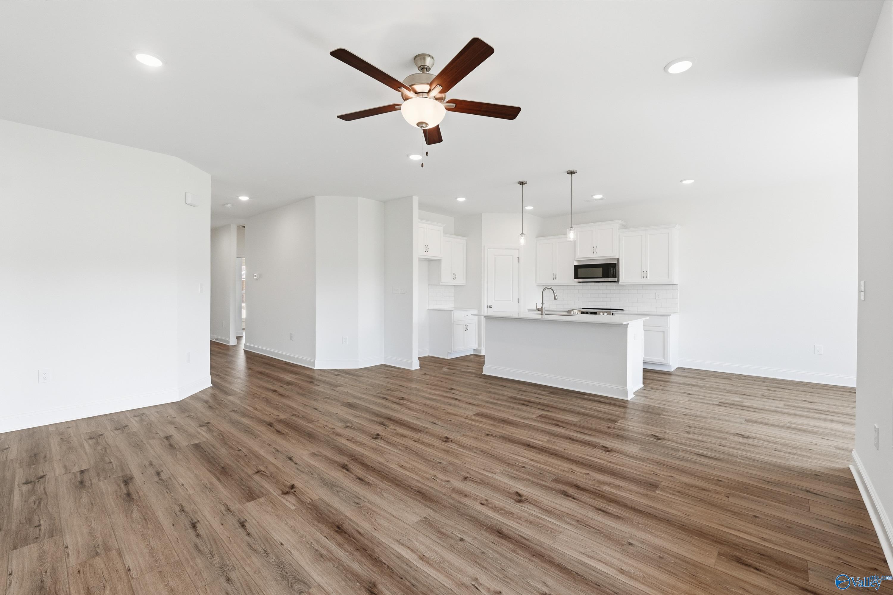 Open-concept living room and kitchen with white cabinets in The Asheville floor plan, Jaguar Hills, Huntsville, Alabama.